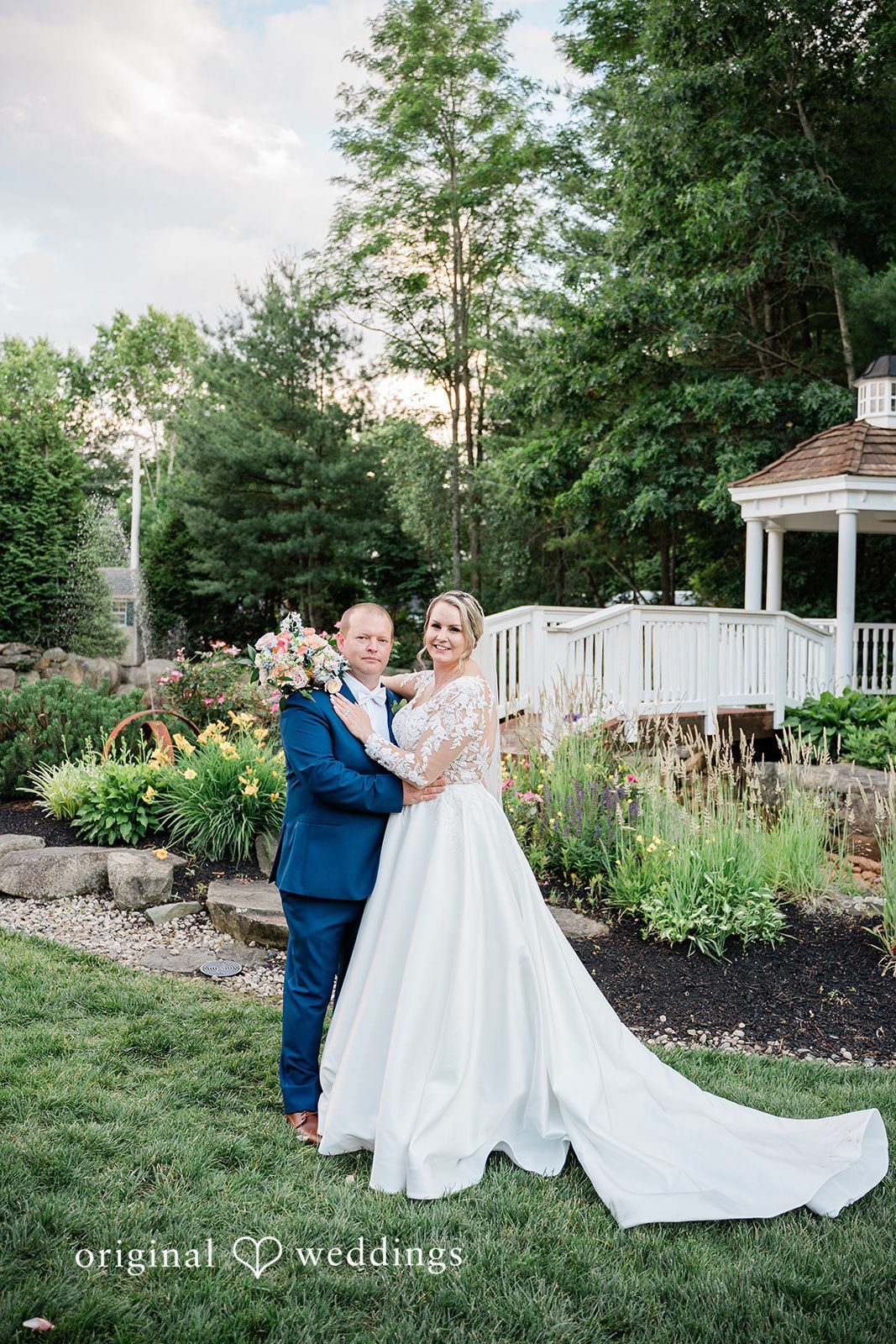 Jessica + Patrick A bride and groom hug each other in a scenic garden setting.