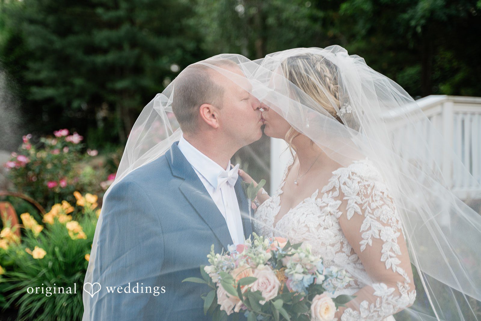 Jessica + Patrick A close-up of a bride and groom kissing under a flowing wedding veil.
