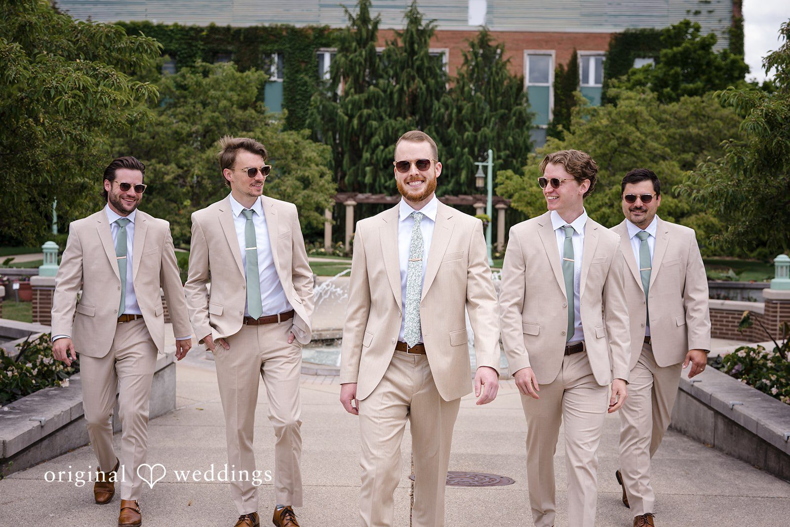 Emily + Maxwell Groom and five groomsmen in light-colored suits walking forward together.