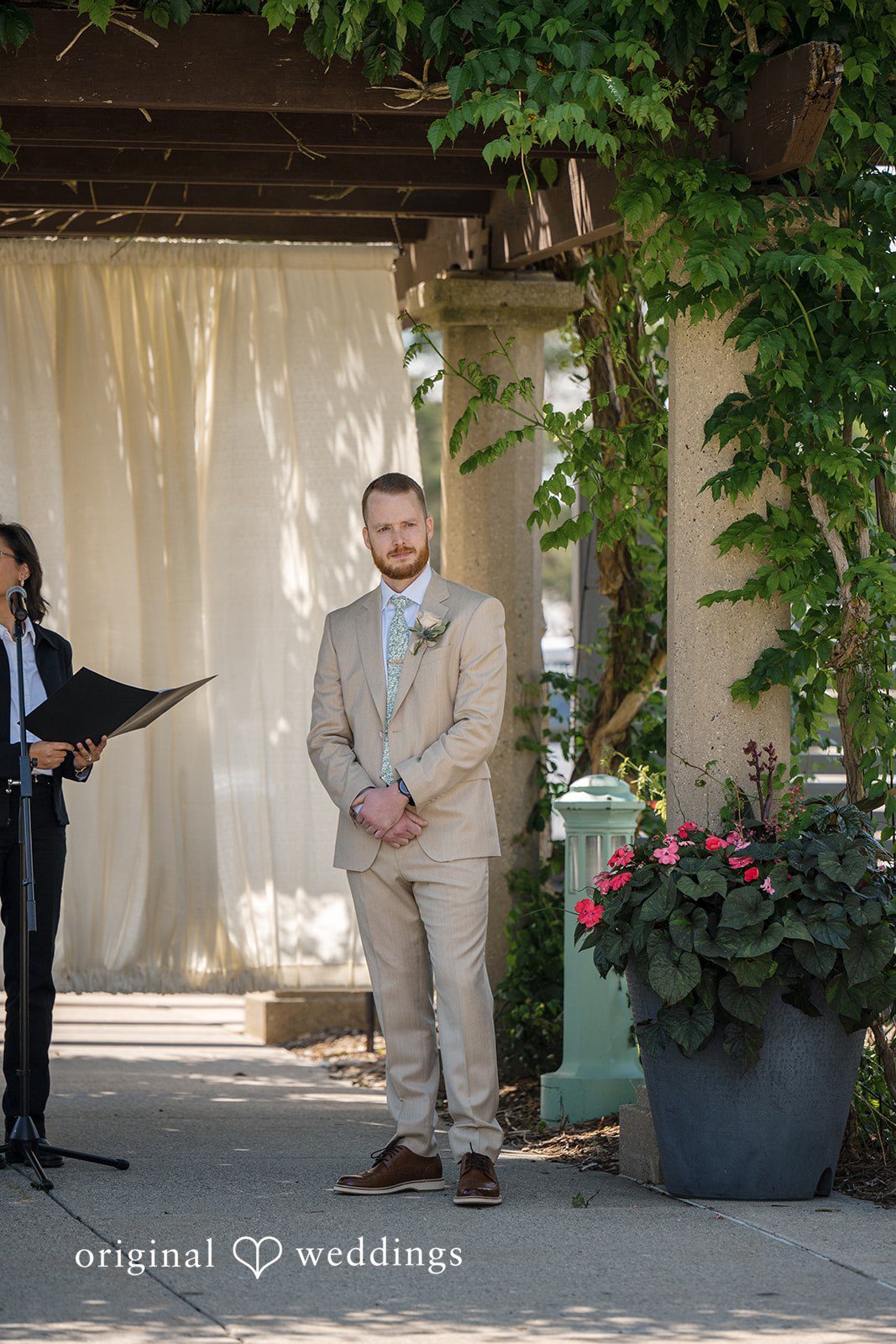 Emily + Maxwell A groom standing before an officiant during a wedding ceremony.