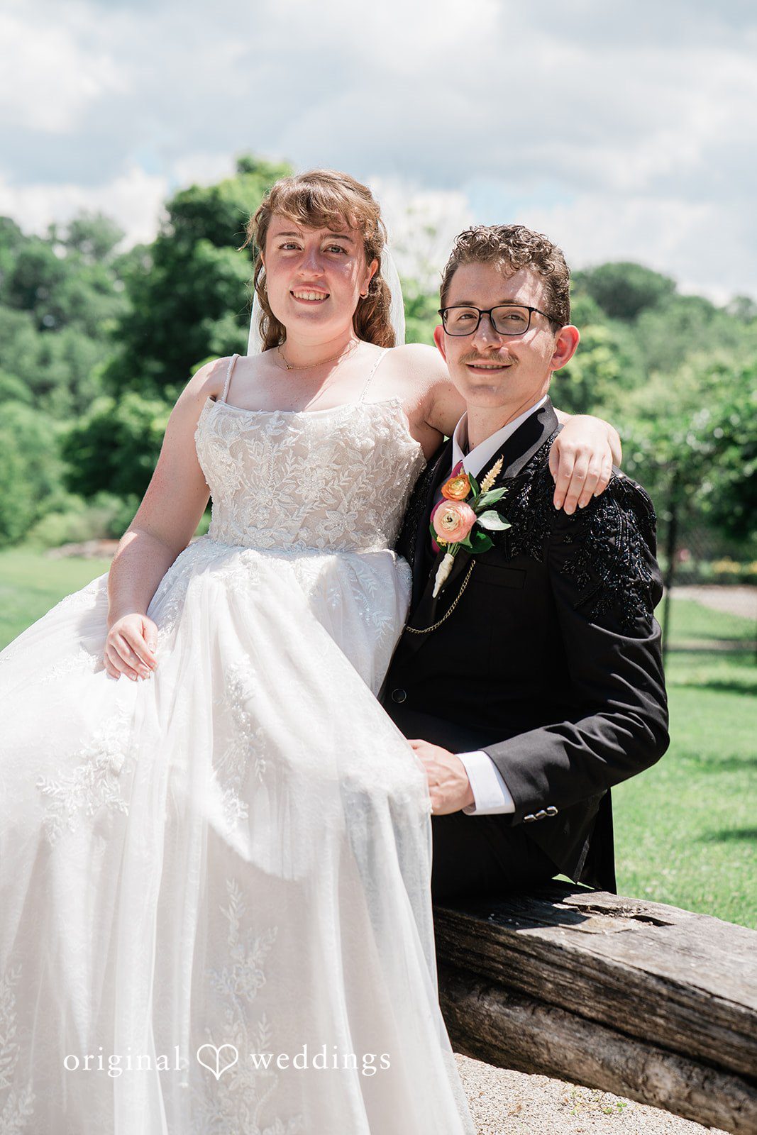 Beautiful picture of bride and groom sitting in a abckyard