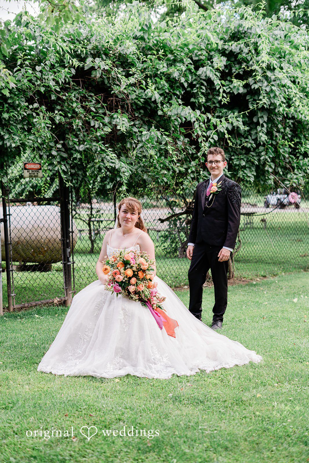 Bride and groom posing for wedding photography in a backyard