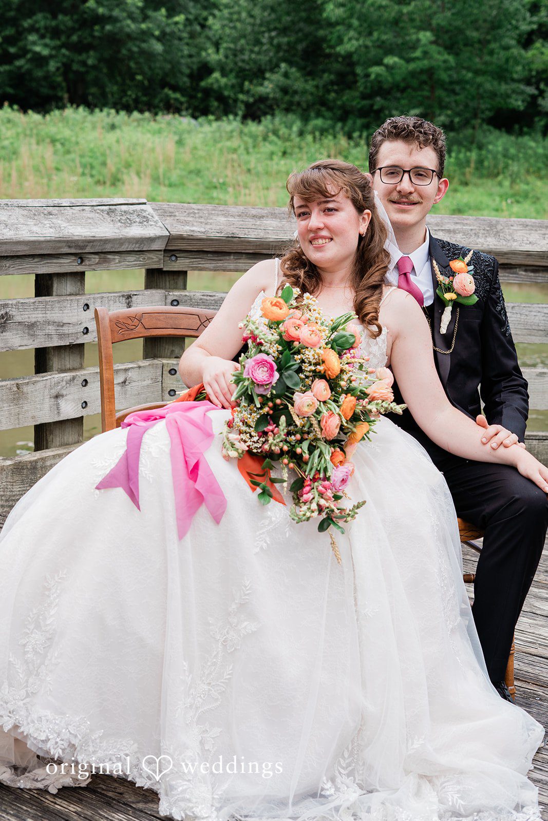 Lovely picture of bride and groom sitting on a bench in a backyard