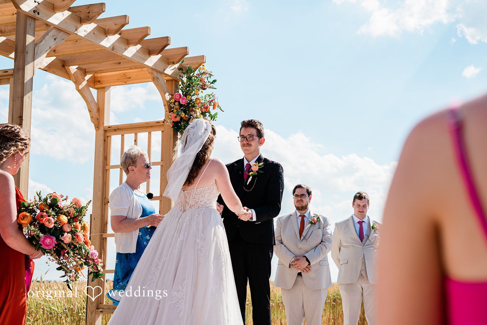 Bride and groom looking at each other with love while holding hands captured by Cleveland wedding photographers from Original Weddings