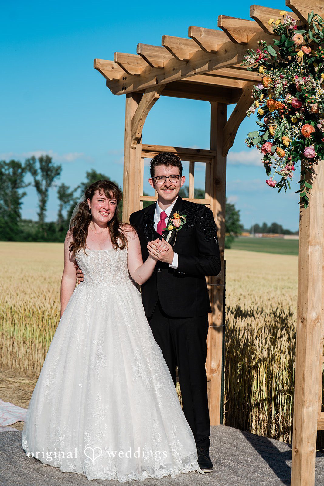 Bride and groom posing for wedding photography while holding hands
