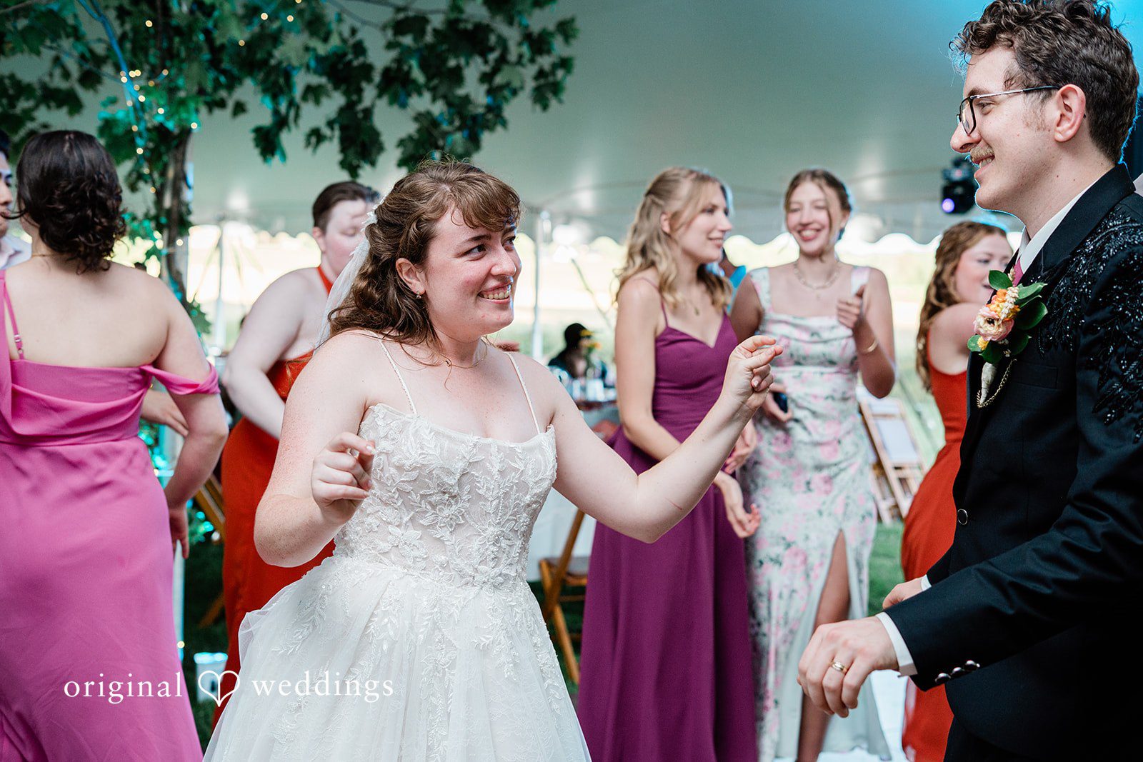 Bride and groom having fun on a dance floor with family and friends