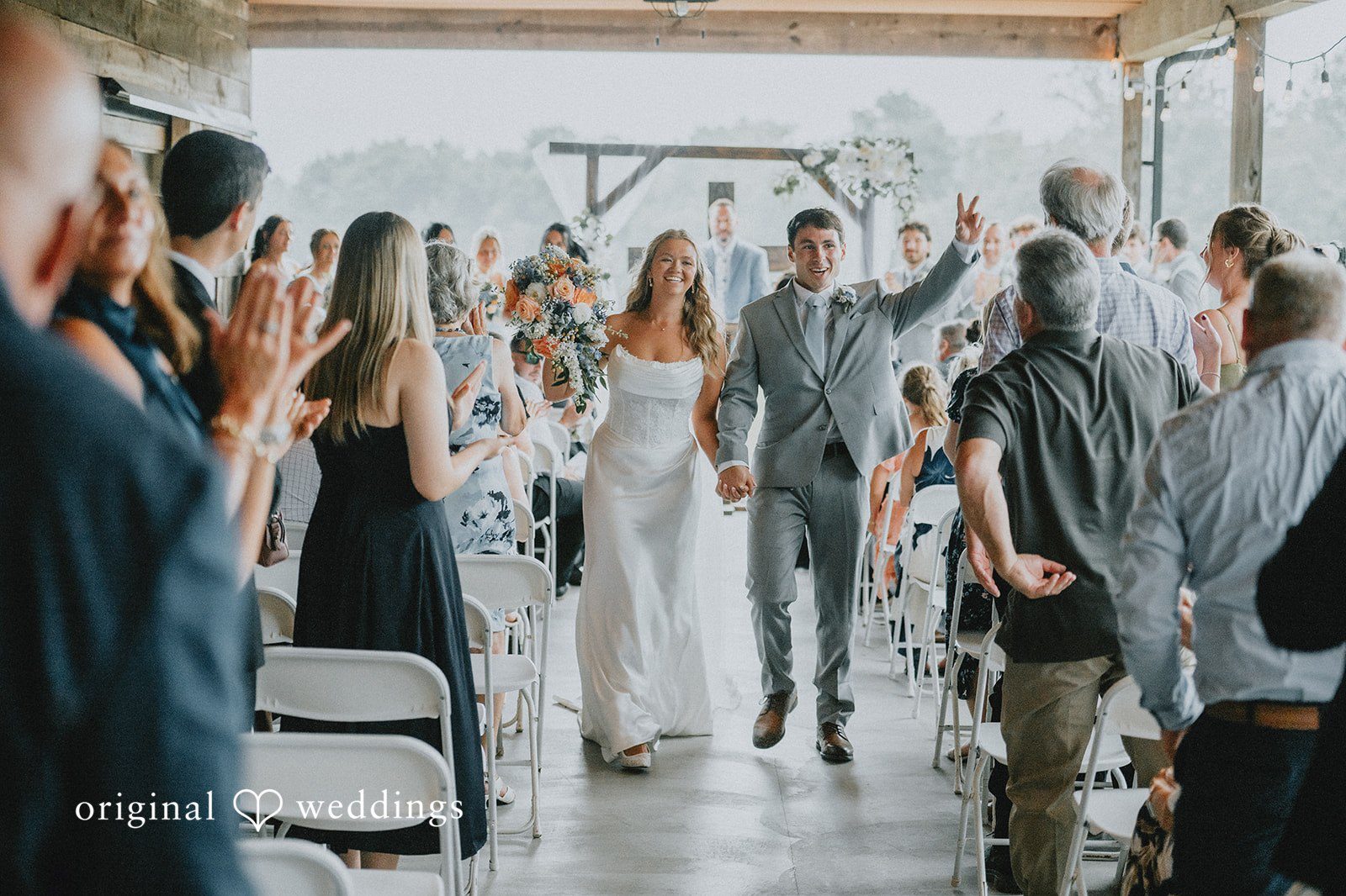 Our Cincinnati wedding photographers at Original Weddings captured a joyful portrait of the couple making a grand exit after an Ohio Backyard ceremony