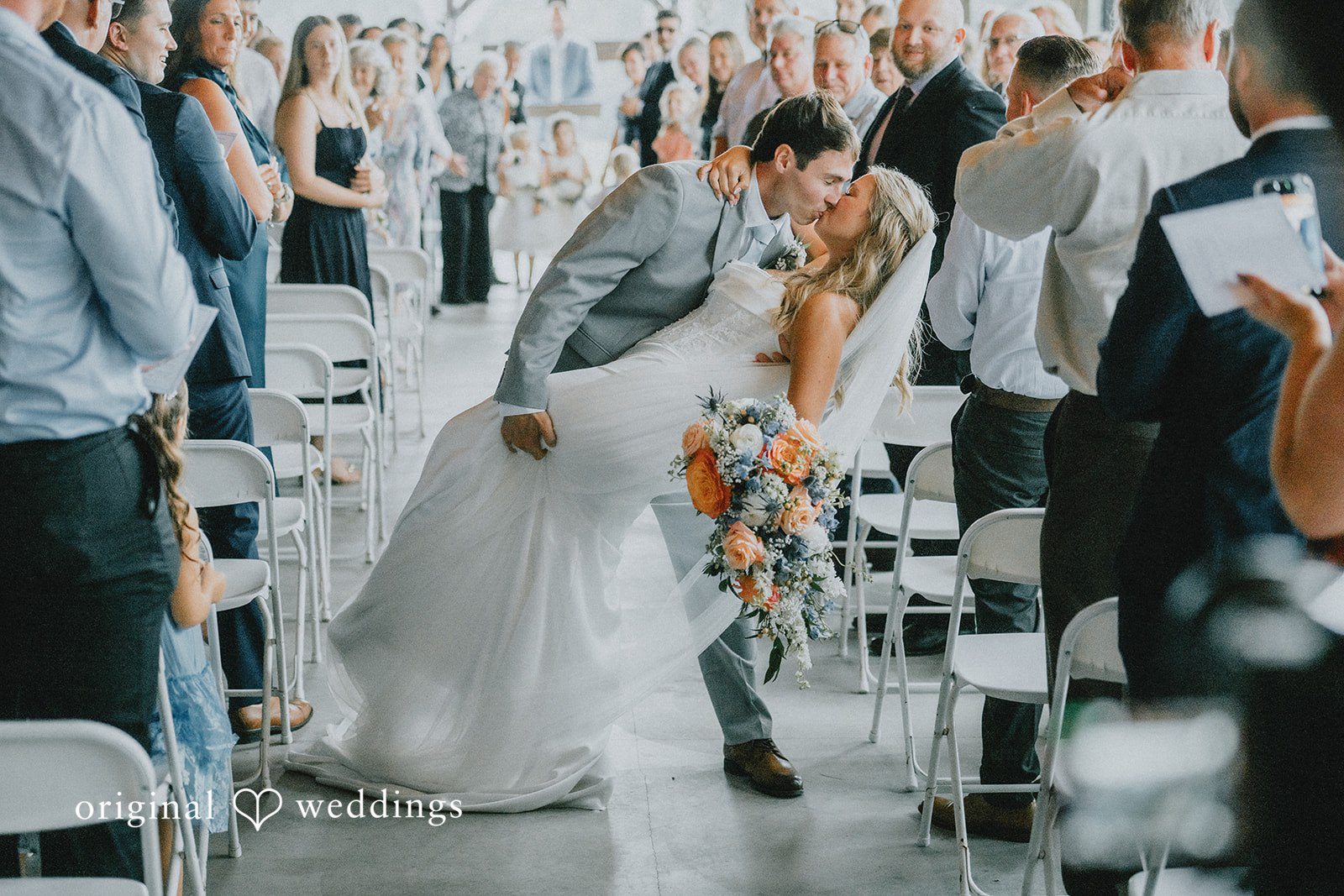 Abby + Tyler The couple shares a romantic kiss on the aisle