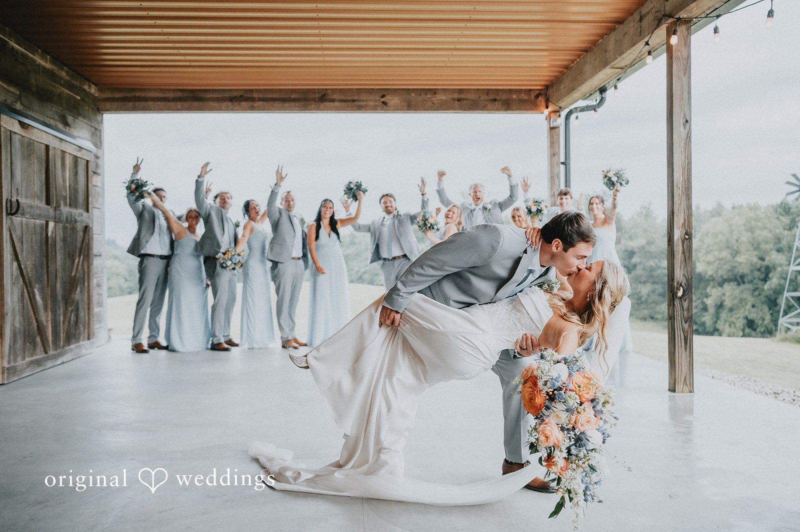 Abby + Tyler The couple shares a romantic kiss with cheers from their bridal party