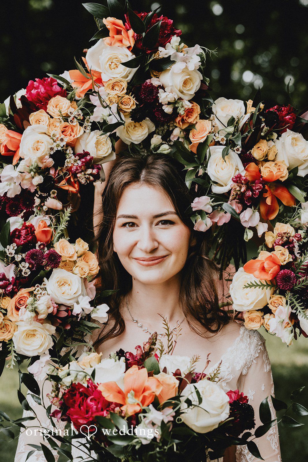 Catherine + Gabriel Smiling bride wearing a large floral crown made of autumn-colored blossoms.