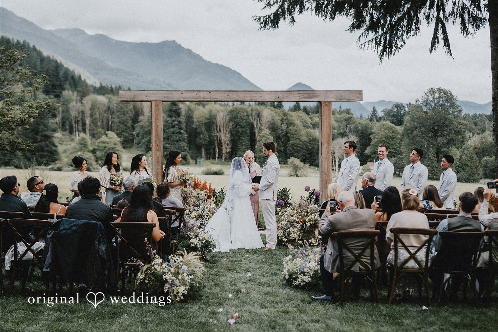 Ben + Erin Bride and groom exchanging rings during outdoor wedding ceremony