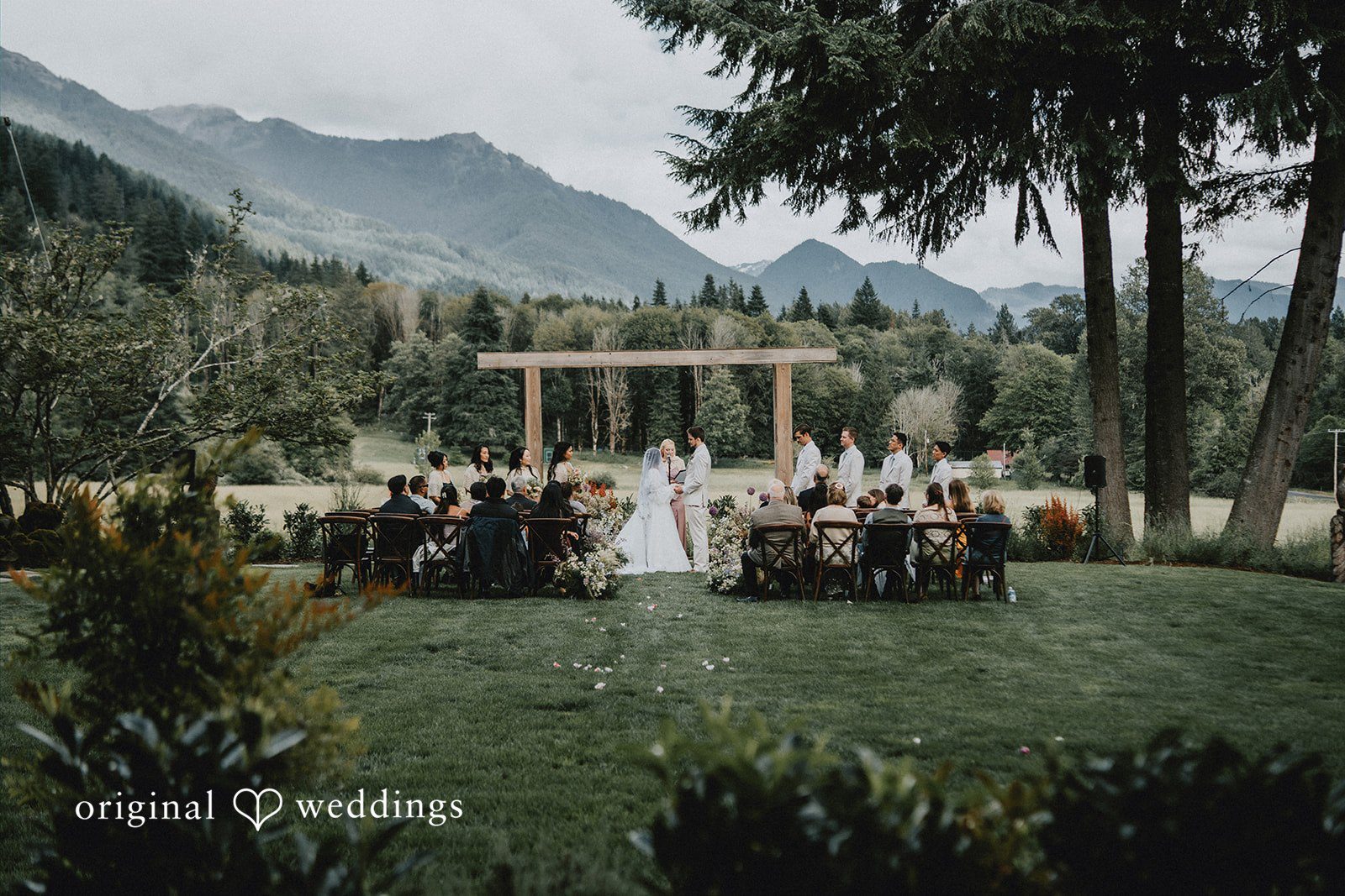 Ben + Erin A wide ceremony view captures the couple exchanging vows surrounded by family and friends