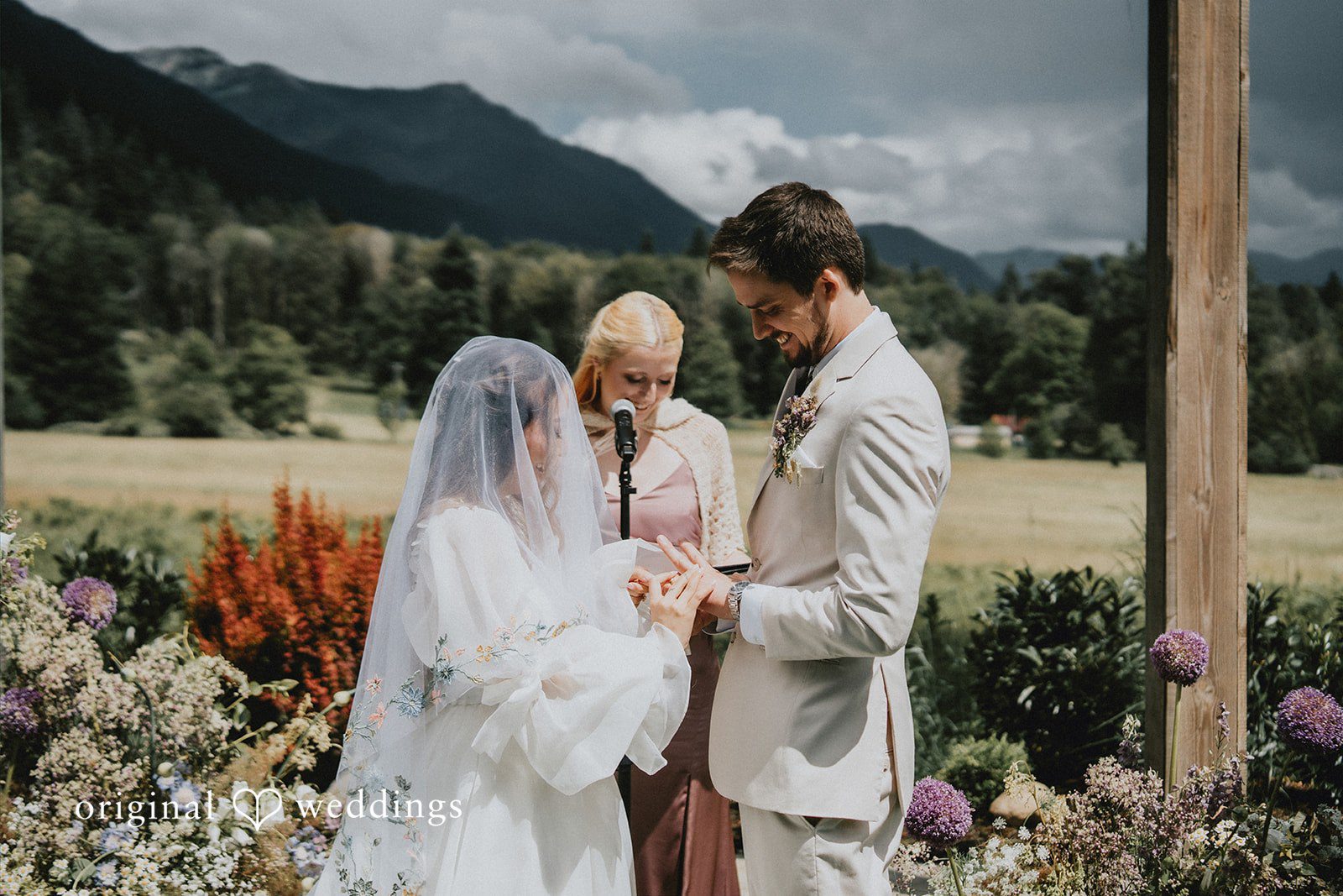 Ben + Erin Bride and groom exchanging rings during outdoor wedding ceremony