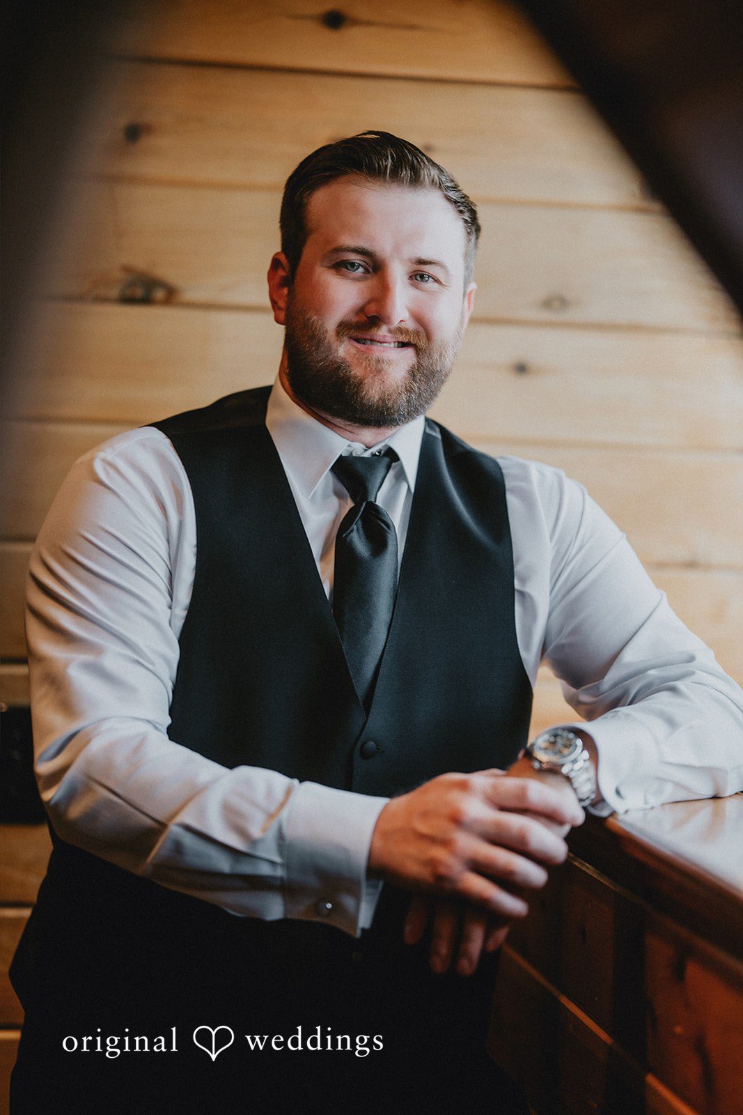 Portrait of a groom wearing a dark vest and tie.