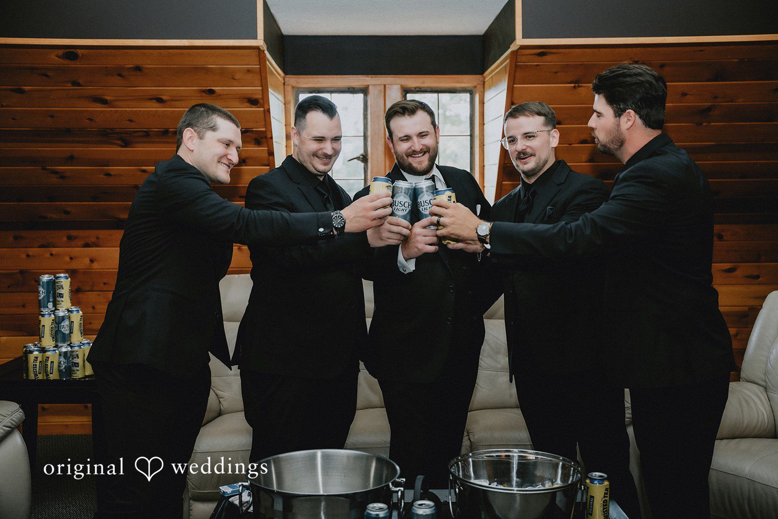 Groom and groomsmen raising their glasses for a toast.