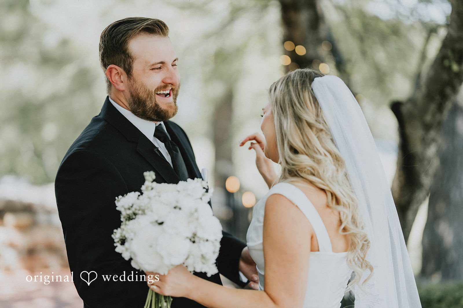 Close-up portrait of the bride and groom smiling together.