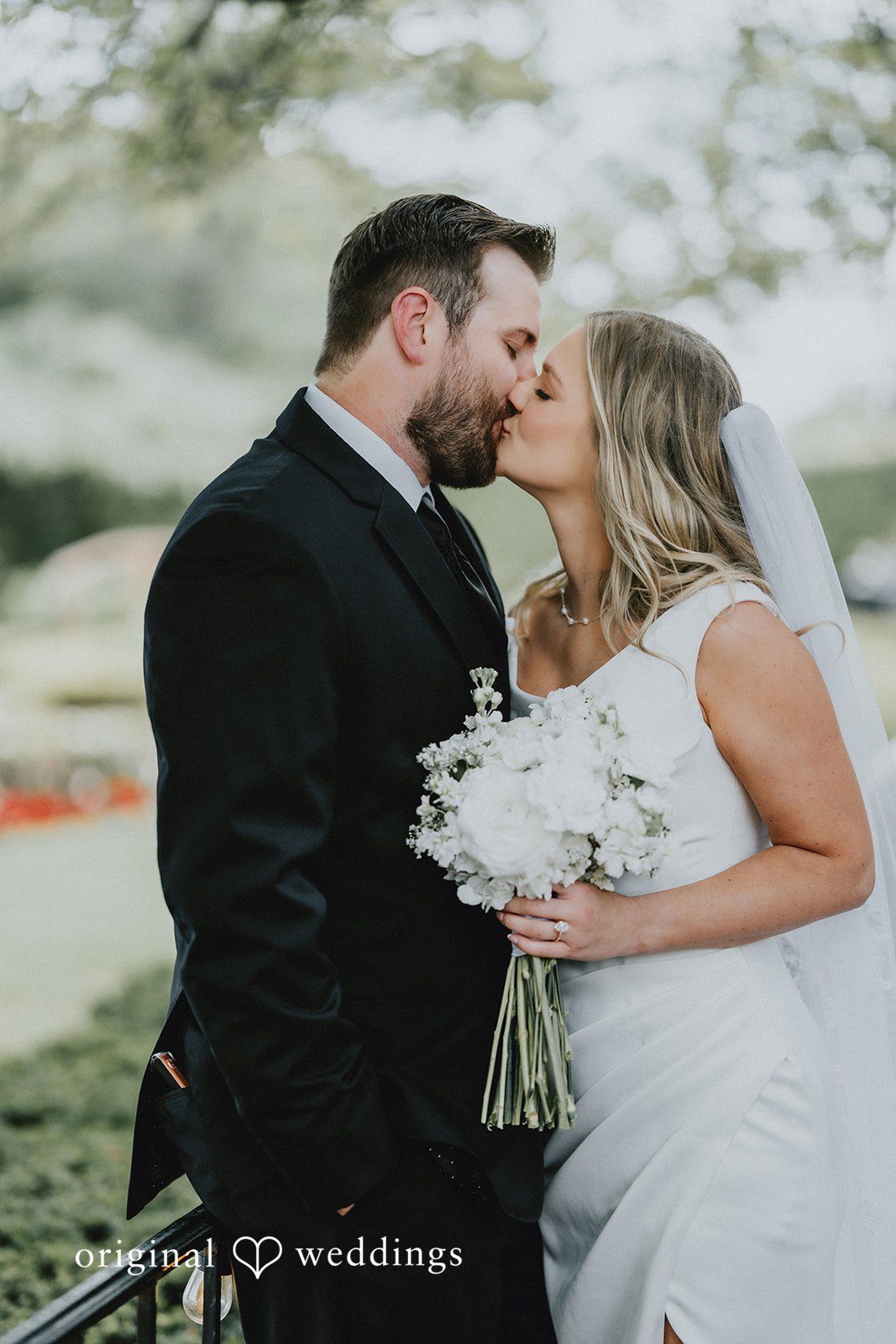 Close-up of the bride and groom sharing a kiss.