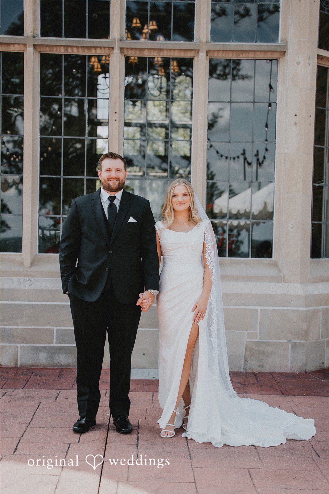 Full-length portrait of the bride and groom standing side-by-side.