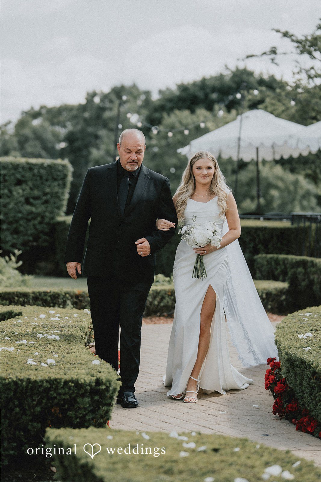 Bride walking down a path next to a man.