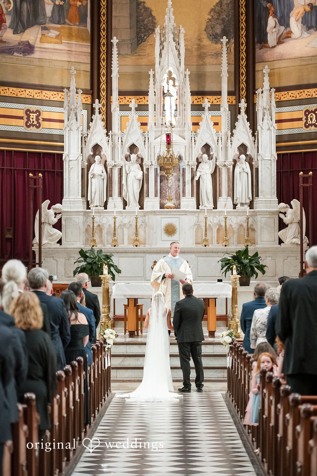 Wide view of a wedding ceremony underway at a grand church altar.