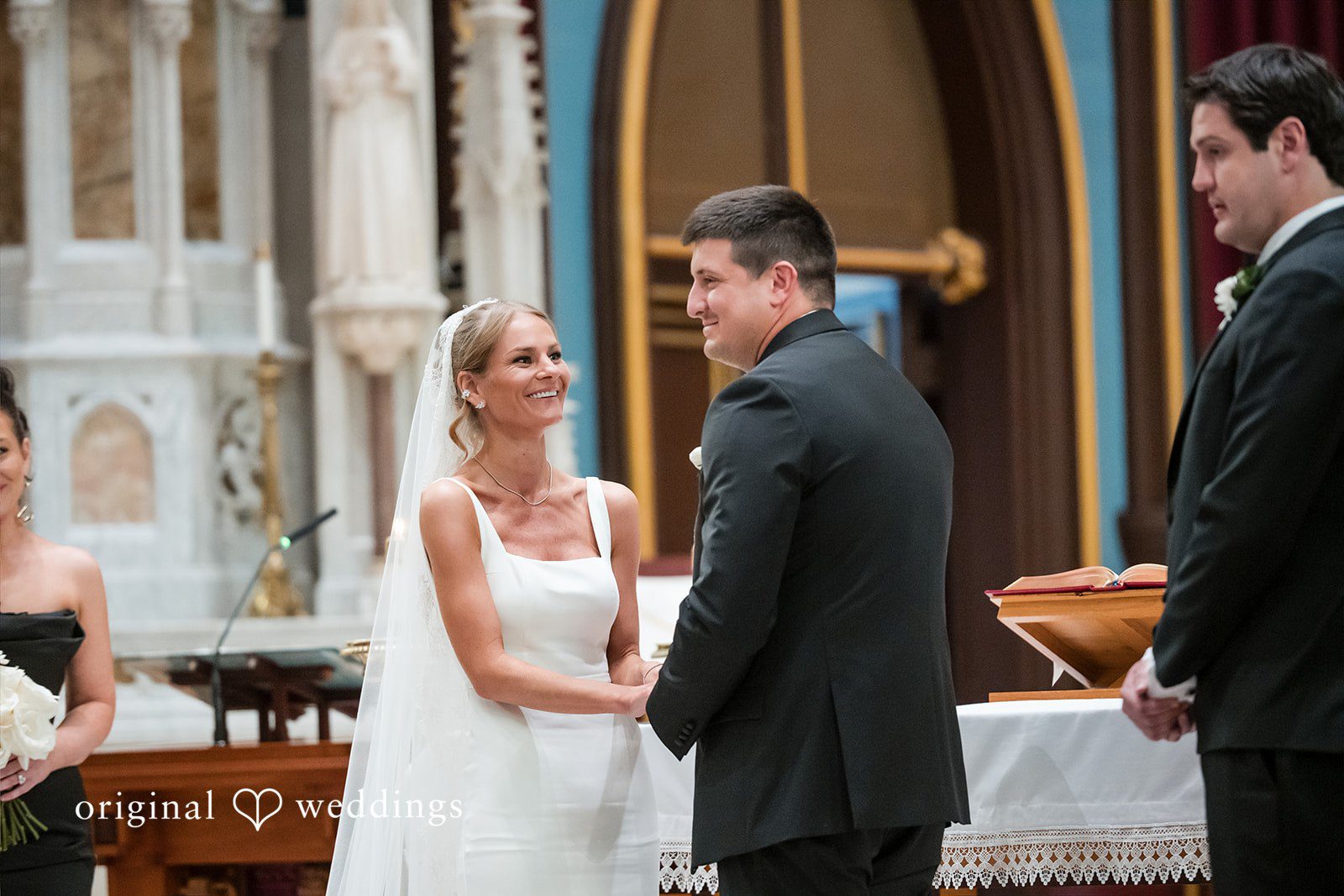 Bride and groom holding hands during their wedding ceremony.