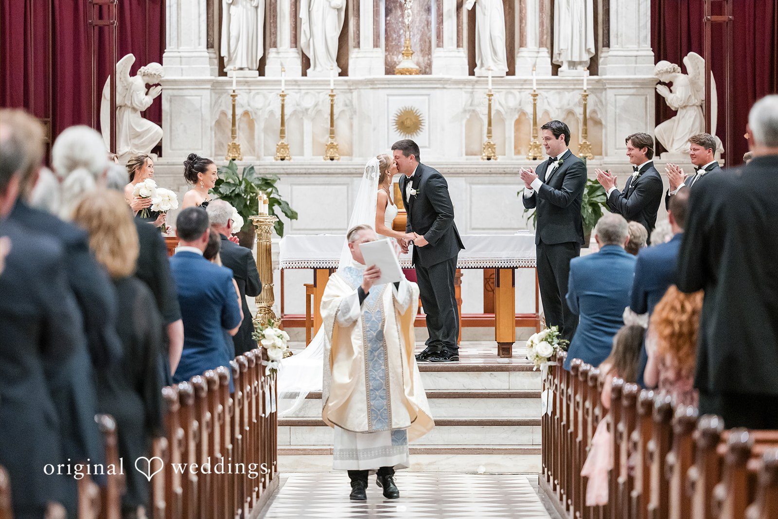Bride walking down the aisle viewed from the back of the church sanctuary.
