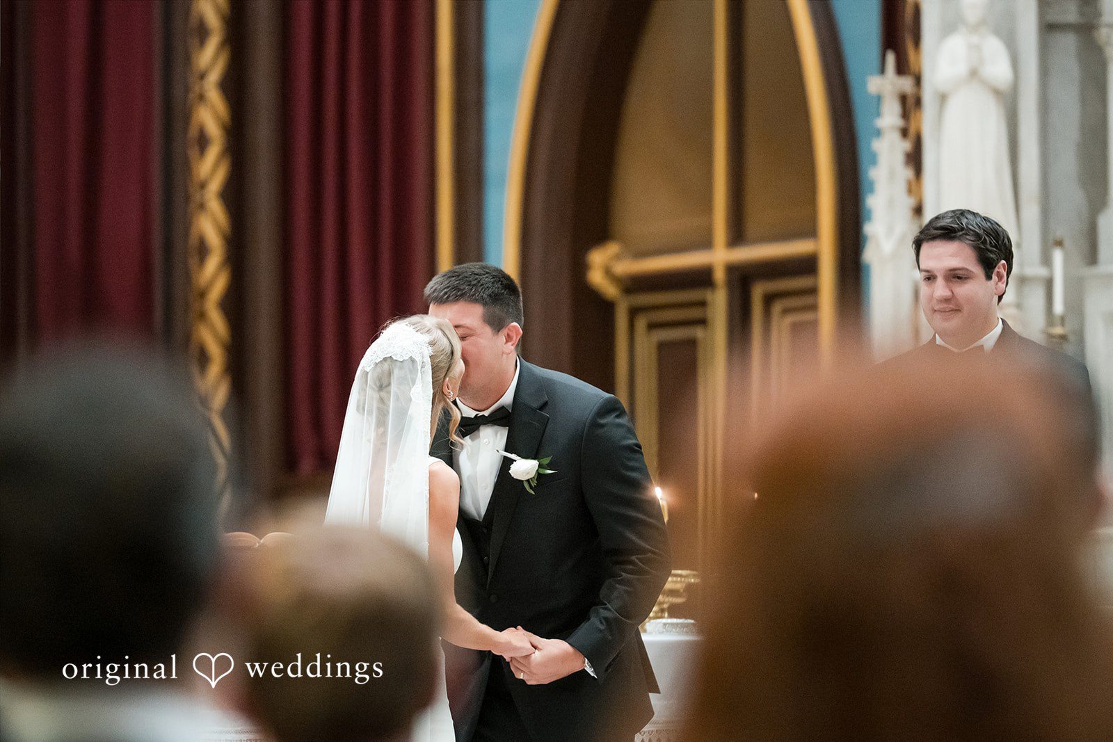 Close-up of a bride and groom sharing a kiss during the ceremony.