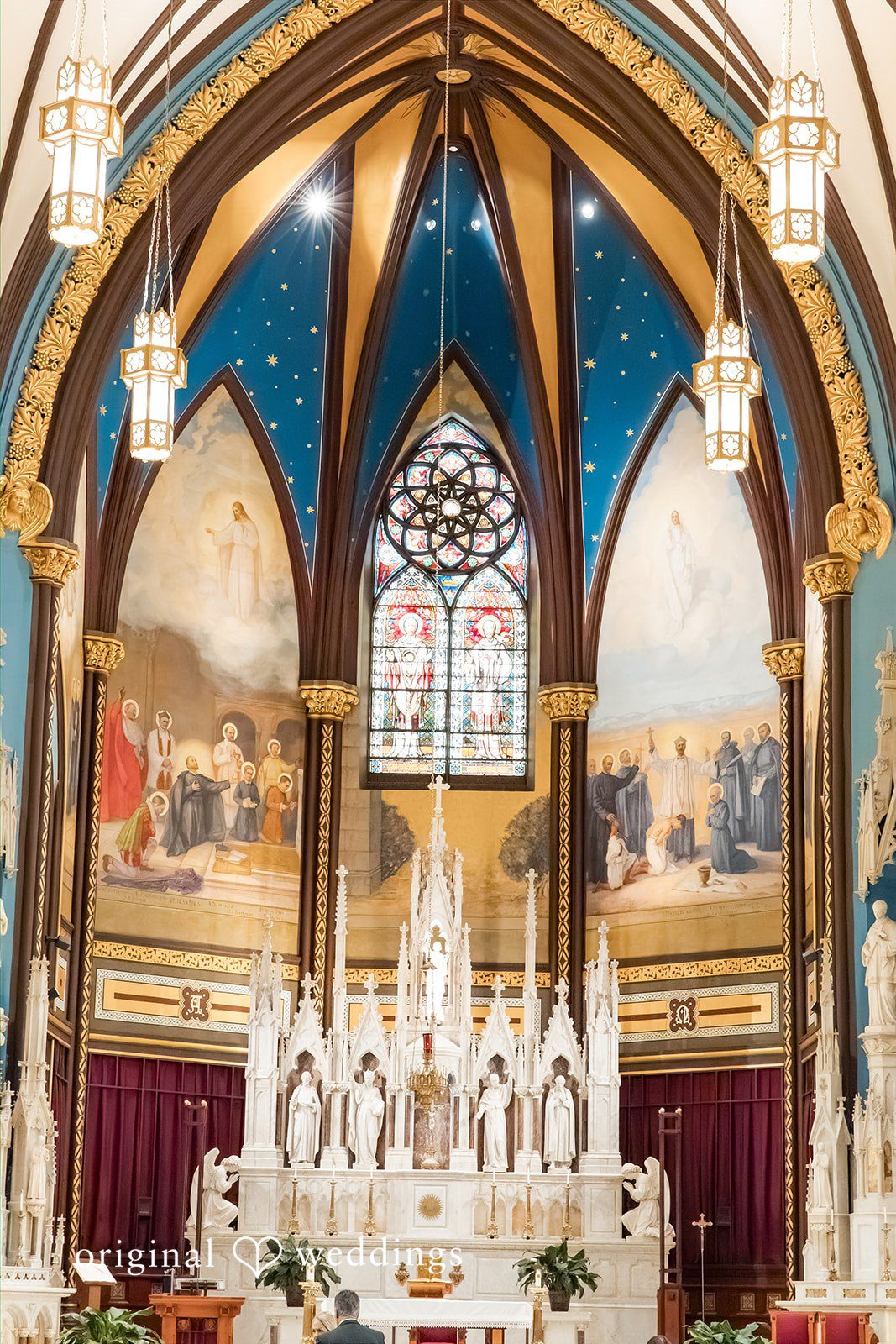 Elaborate church altar with a grand archway and stained glass.