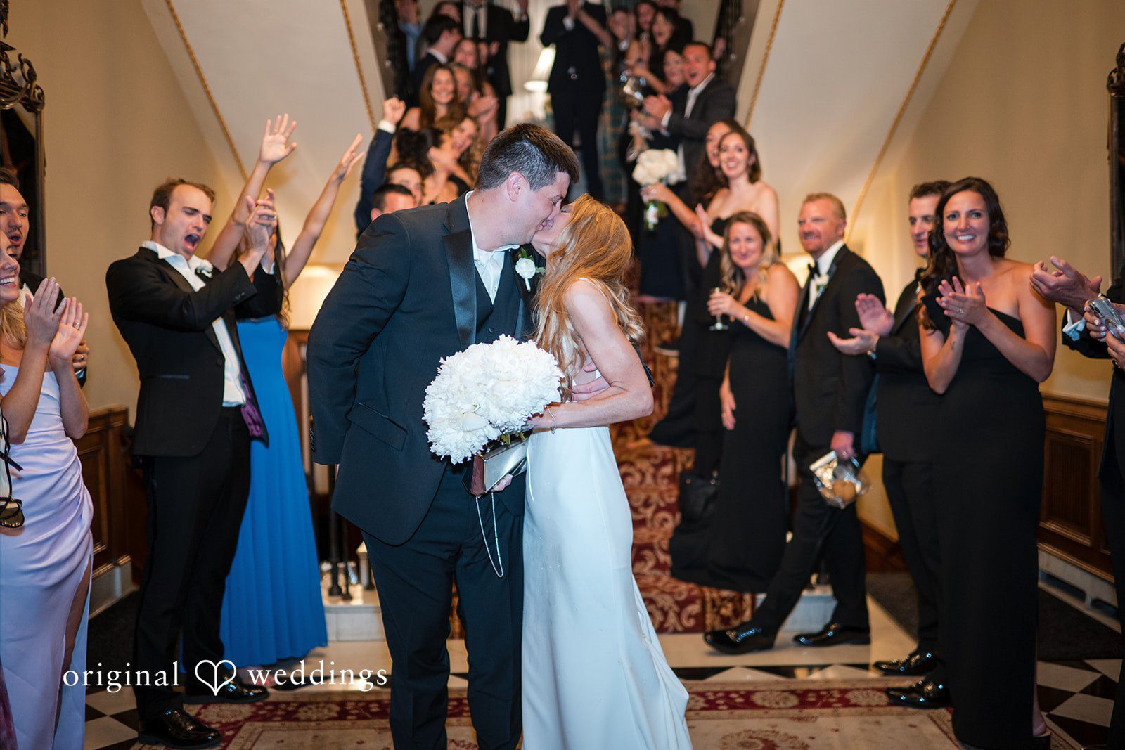 Bride and groom walking through a crowd of applauding reception guests
