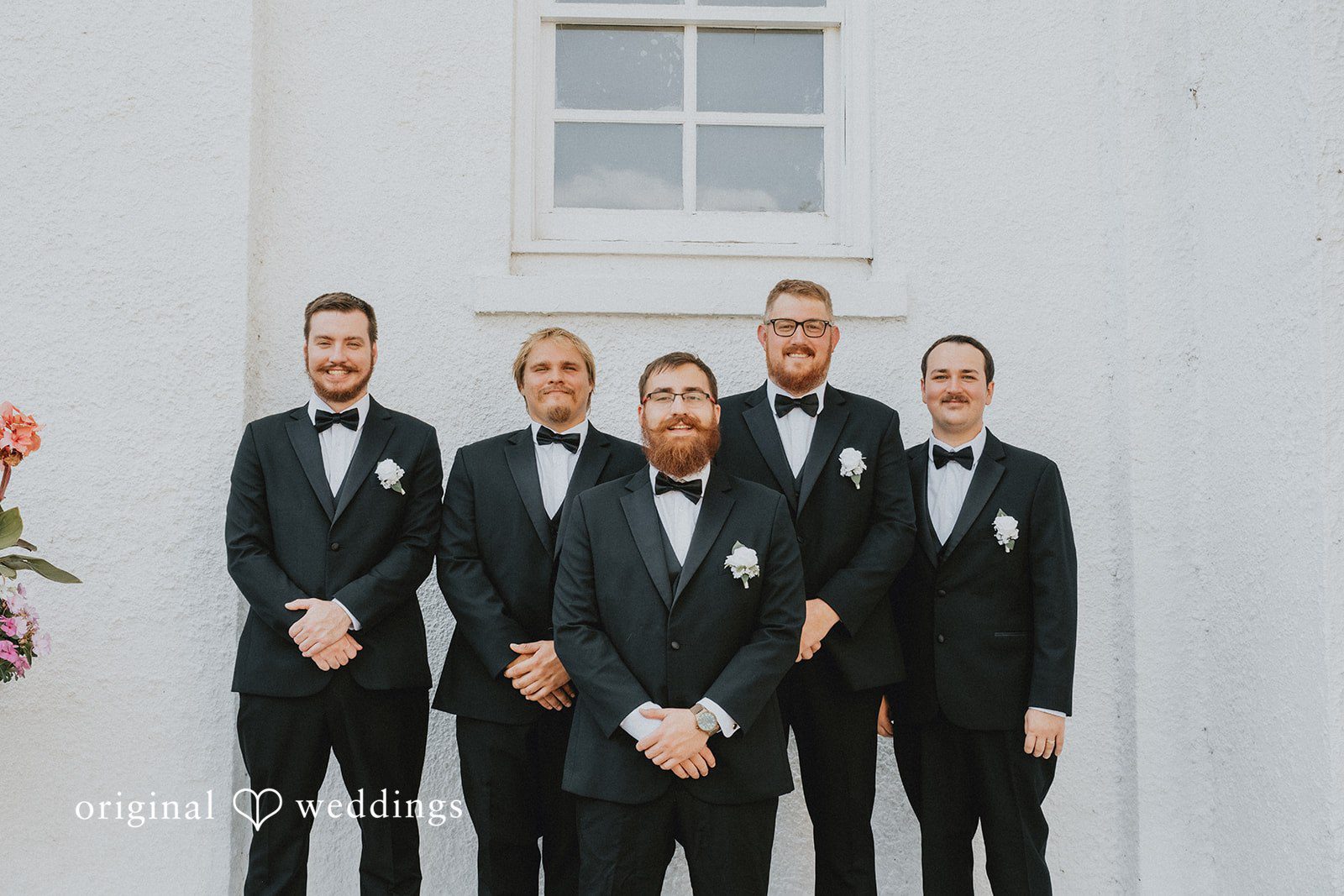 Carly + Dillon A groom posing with his groomsmen all dressed in formal black tuxedos.