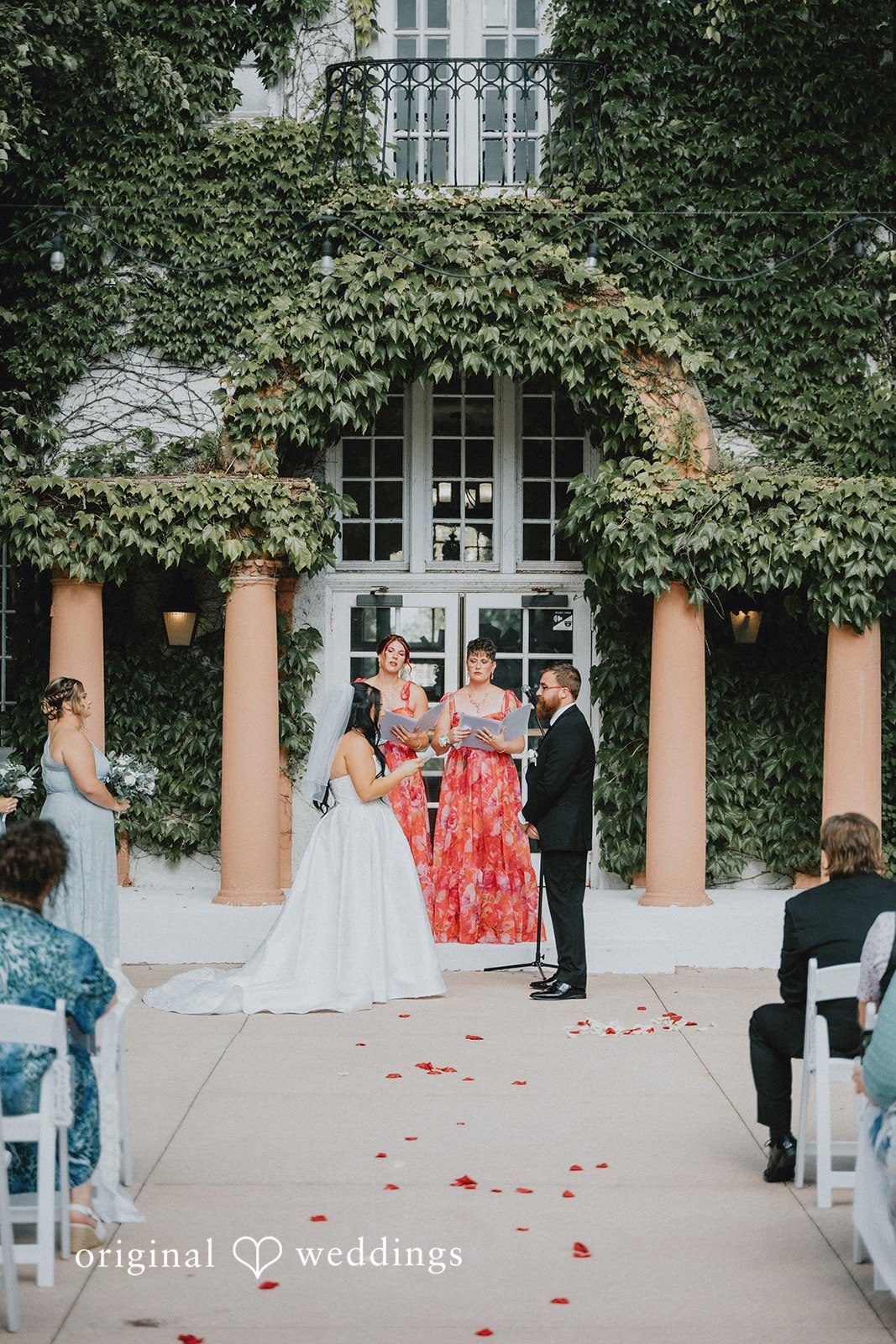 Carly + Dillon A bride and groom sharing a moment during an event with guests seated around them.