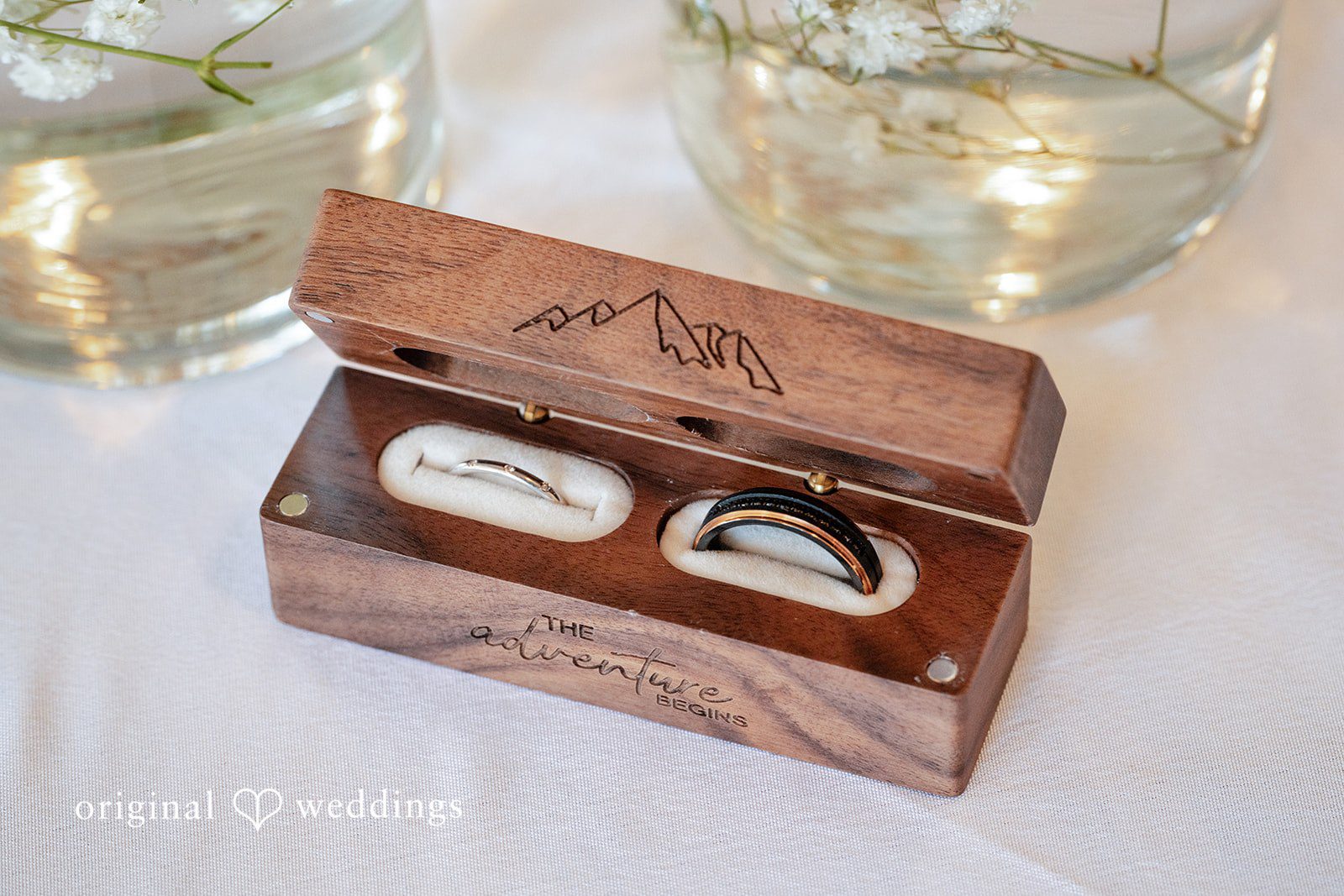 Victoria + Skyler Open wooden box holding two wedding rings.