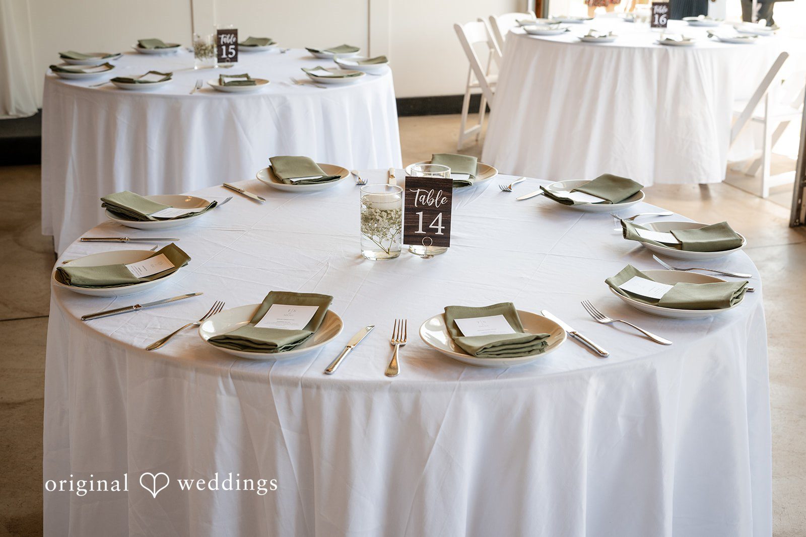 Victoria + Skyler Round banquet table set with white linens and dinnerware.