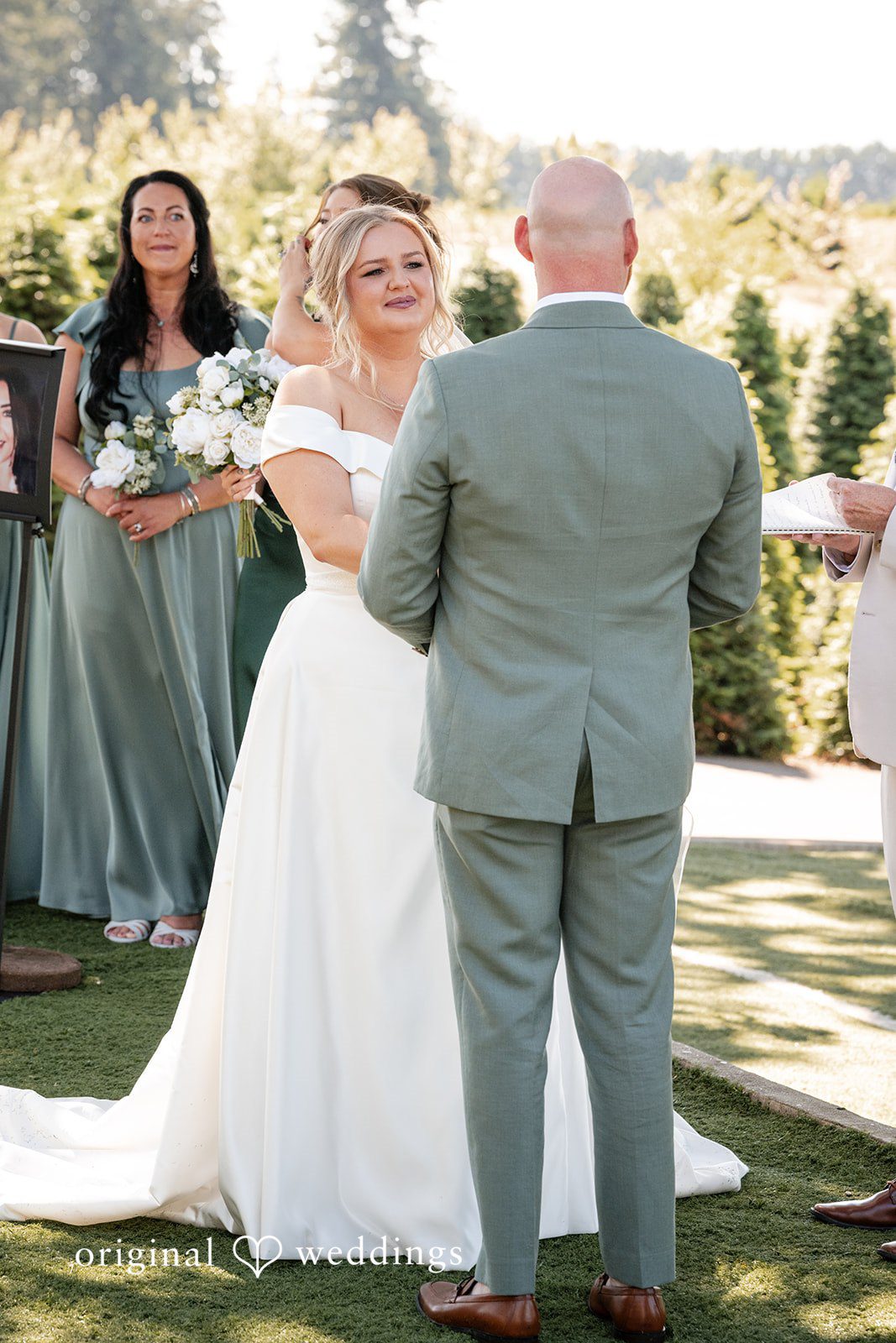 Victoria + Skyler Bride and groom viewed from behind during their wedding vows.
