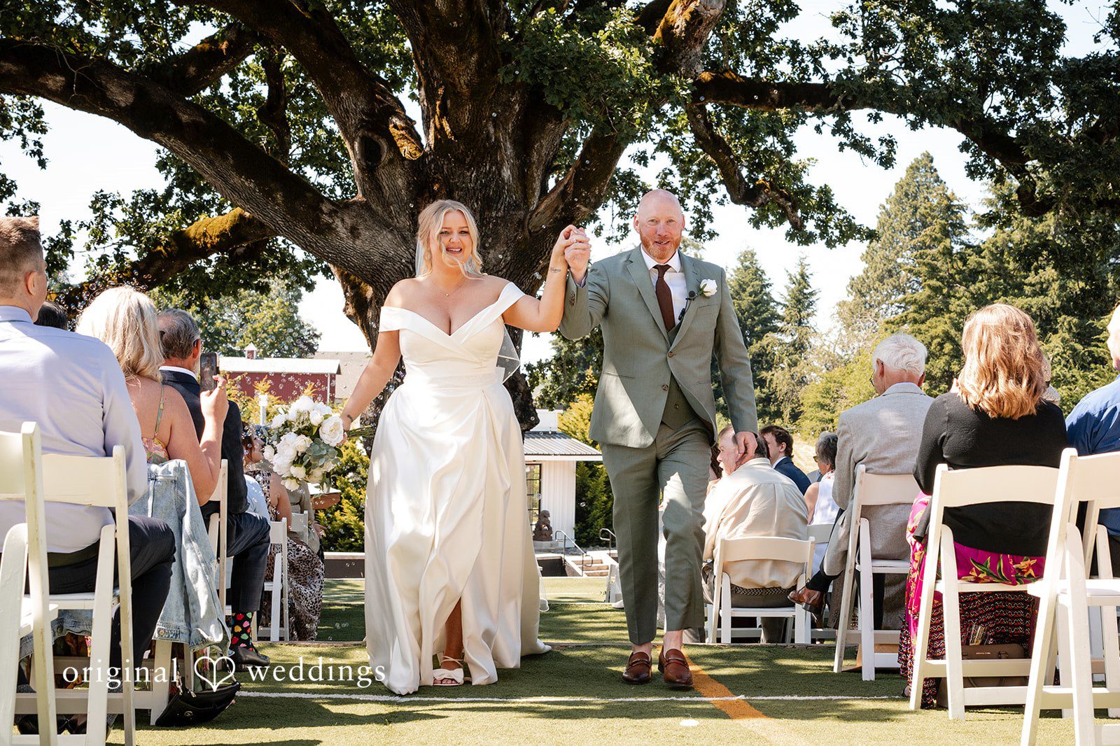 Victoria + Skyler Newlyweds walking down the aisle together while guests watch.