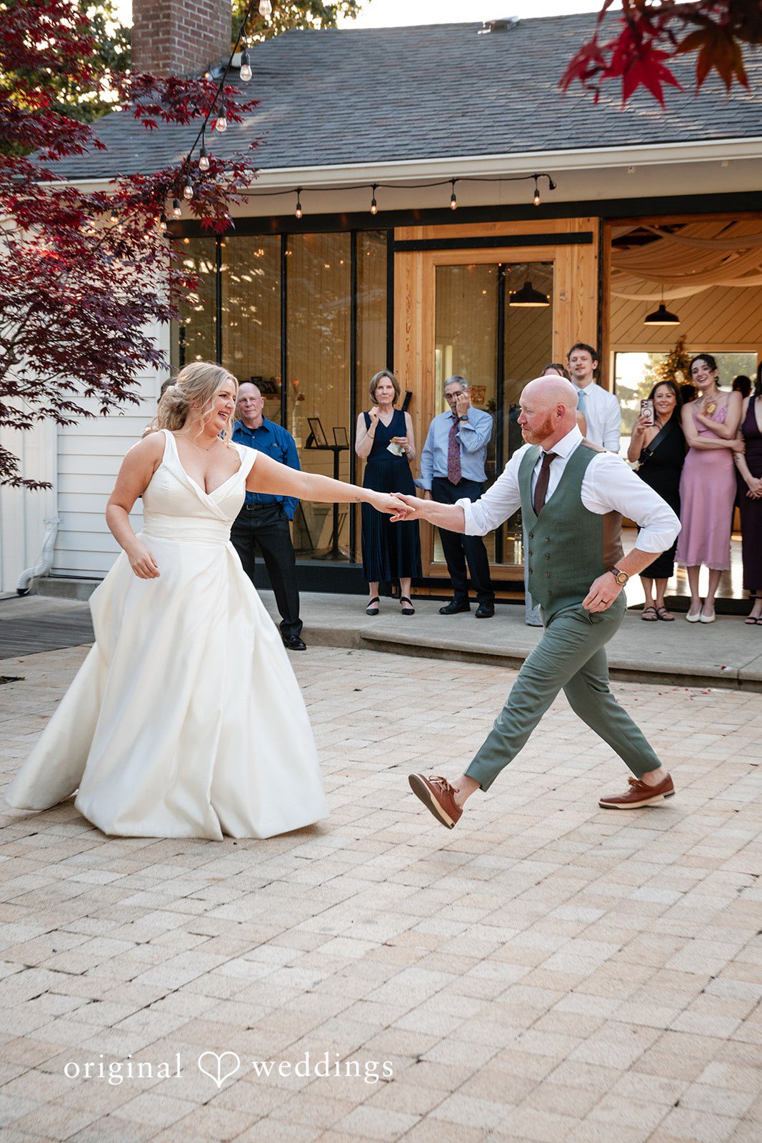 Victoria + Skyler Bride and groom holding hands while dancing during their reception.