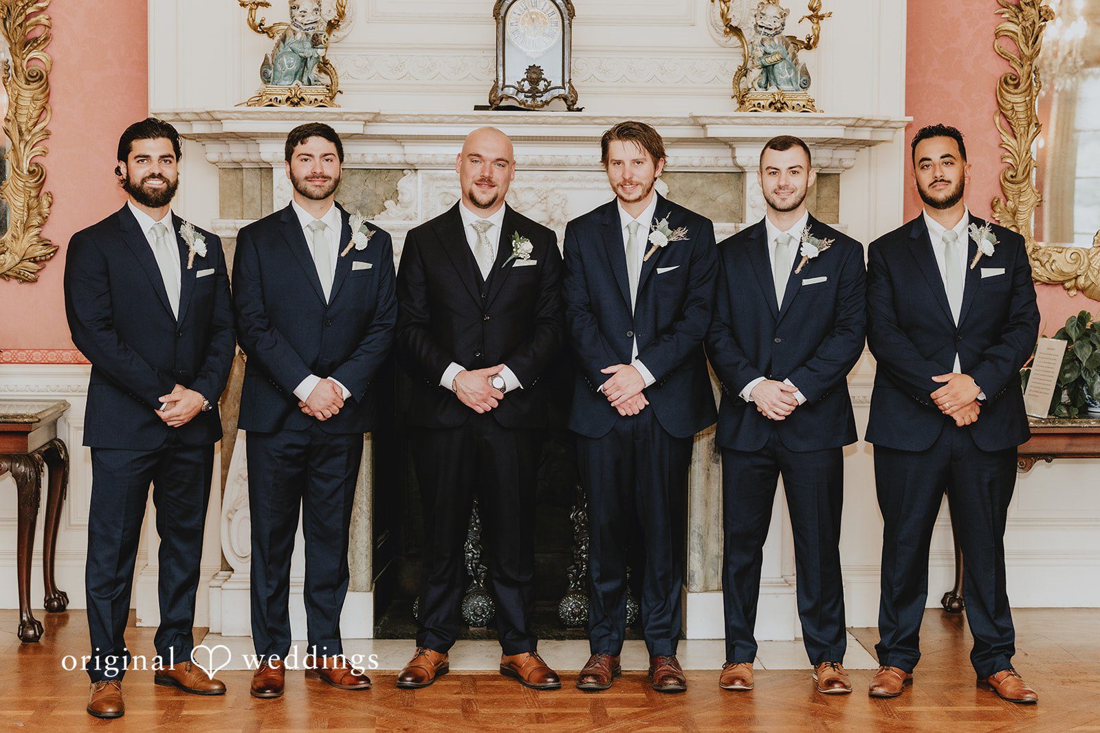 Samantha + Michael Groom and his groomsmen smiling in matching dark suits.