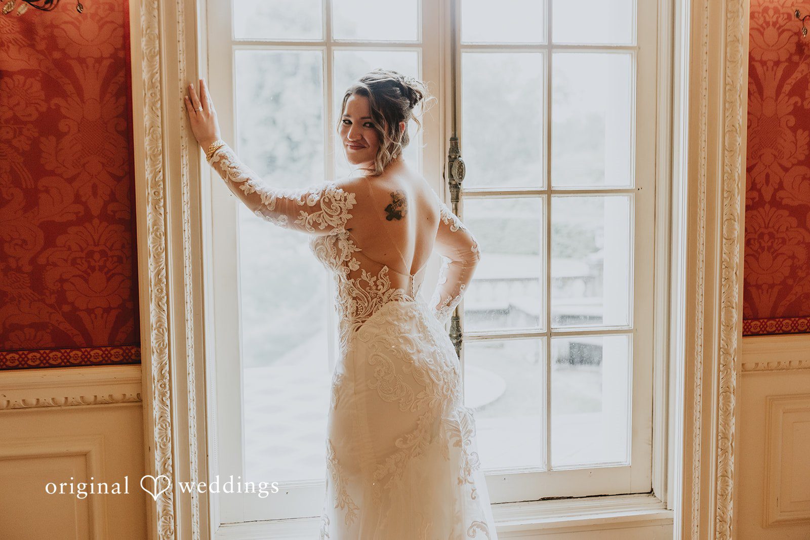 Samantha + Michael Silhouette of a bride standing in front of a large window.