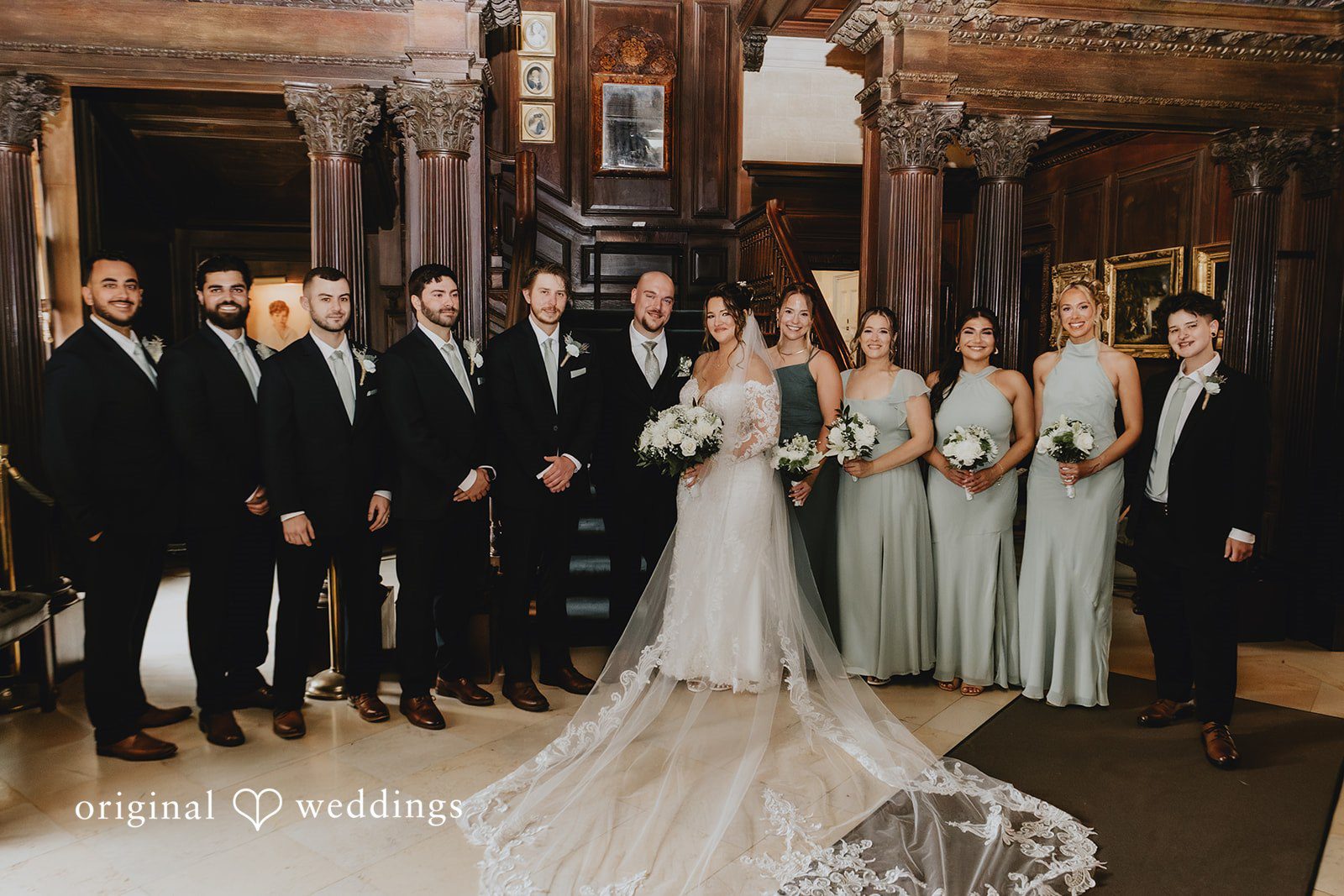 Samantha + Michael Full wedding party posing together in a brick reception hall.