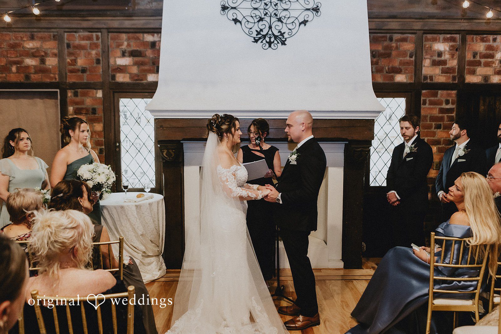 Samantha + Michael Wedding ceremony taking place in front of a large brick fireplace.