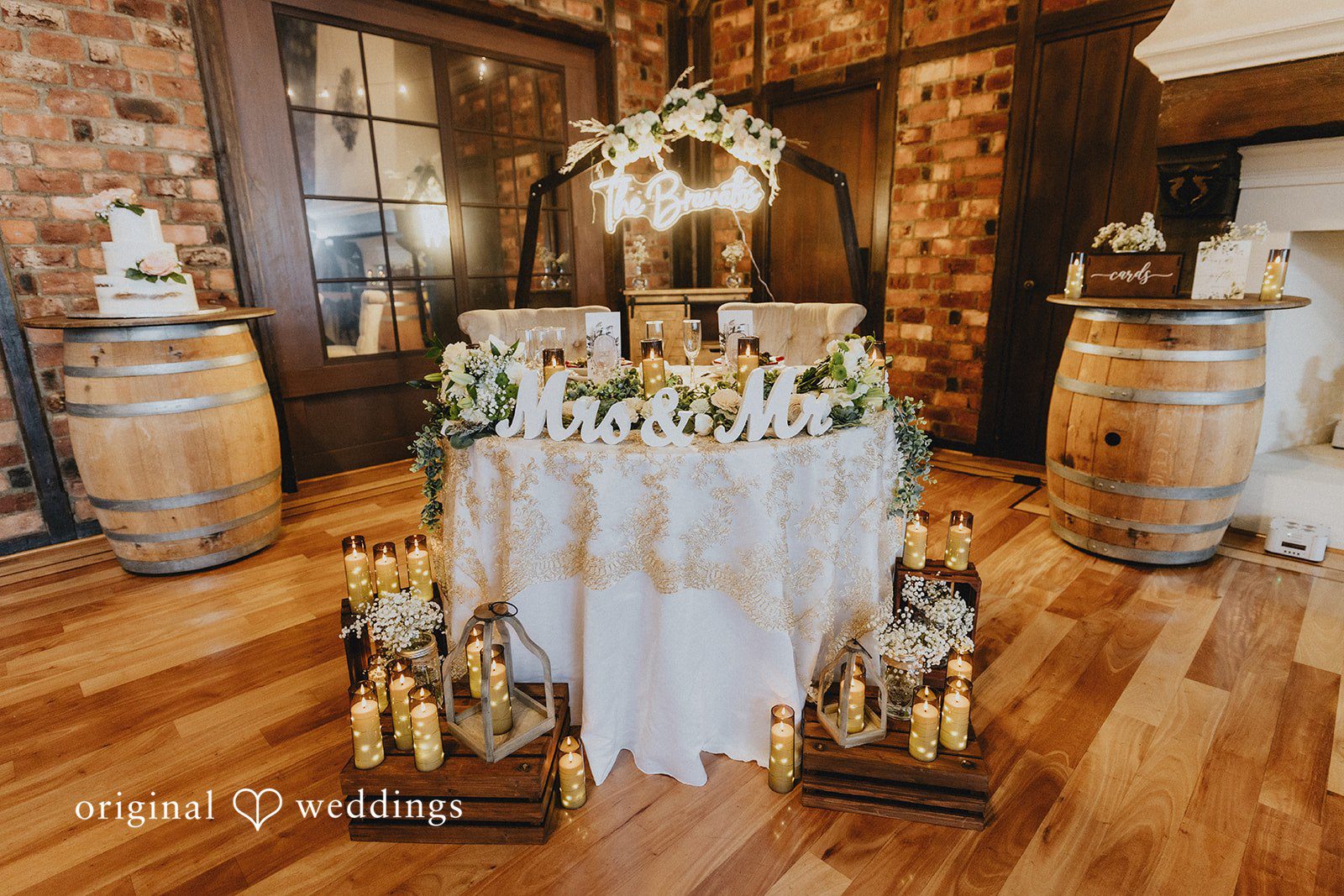 Samantha + Michael Decorated reception table featuring floral arrangements and rustic barrels.