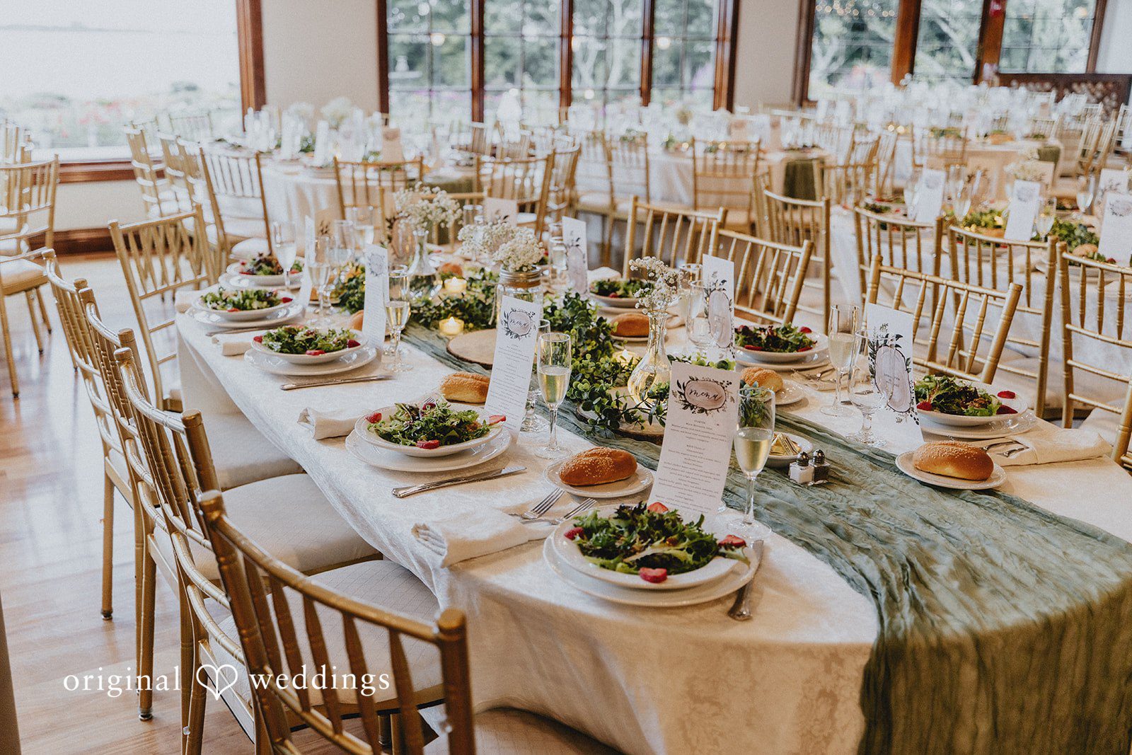 Samantha + Michael Long banquet tables arranged with greenery runners for a reception.
