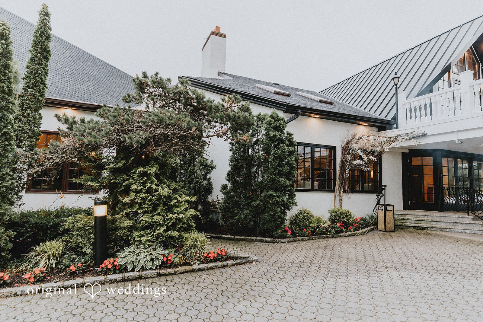 Samantha + Michael White venue building with a pathway and manicured greenery.