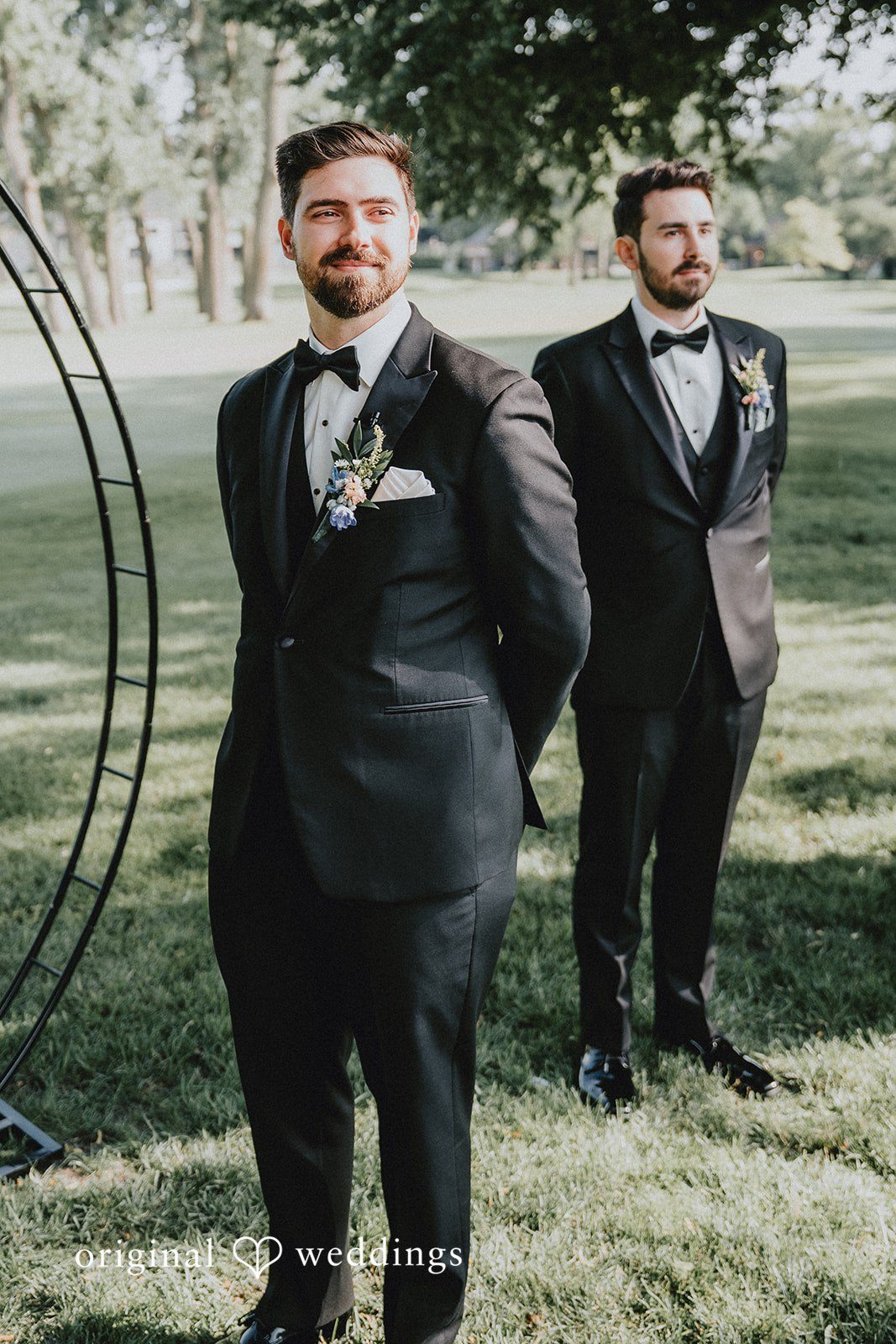 Brandon + Natalie A groom in formal wear posing in a long line on a lawn.