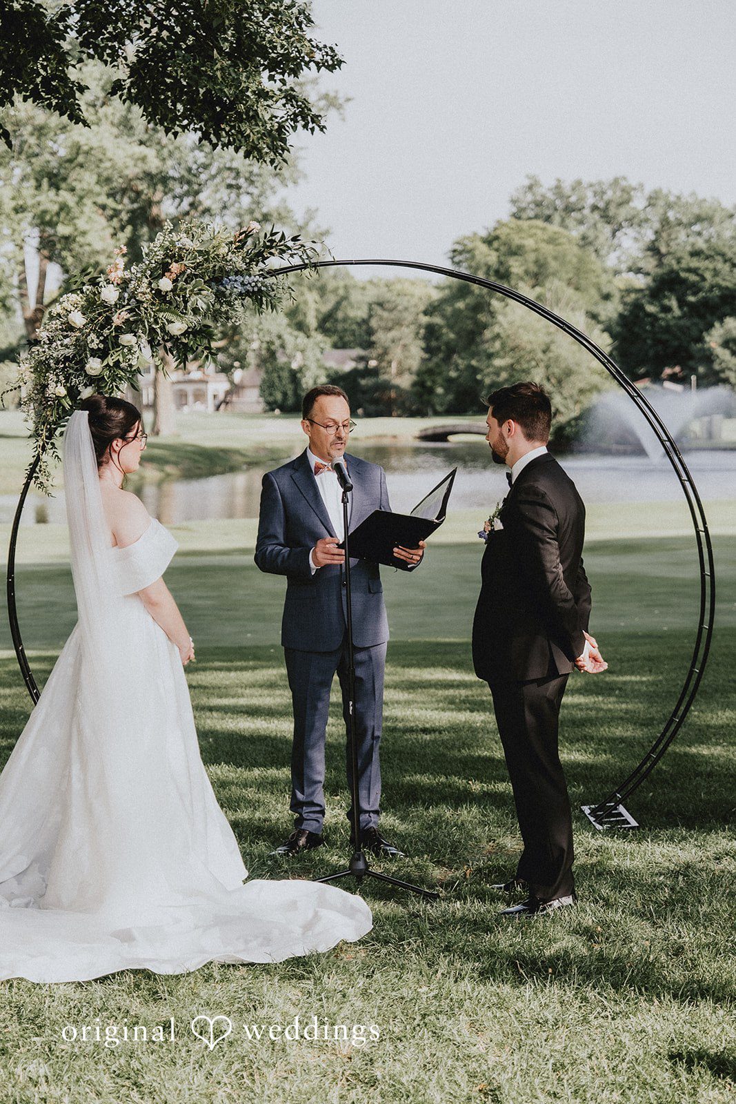 Brandon + Natalie A bride and groom exchanging vows in front of a wedding officiant.