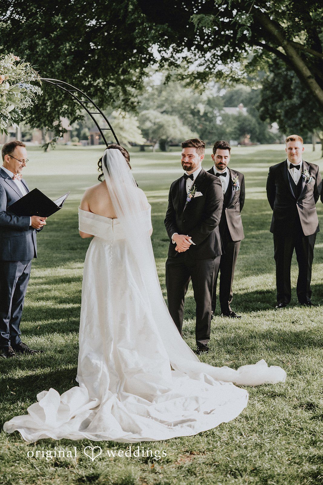 Brandon + Natalie A bride and groom standing together during a wedding ceremony with guests looking on.