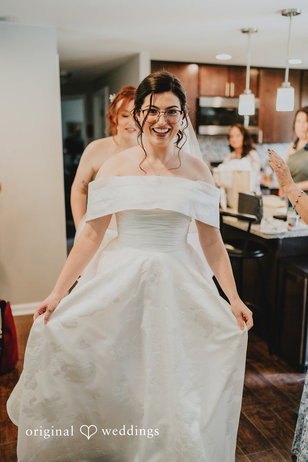 Brandon + Natalie A bride holding up her white wedding gown at Rolling Green Country Club.
