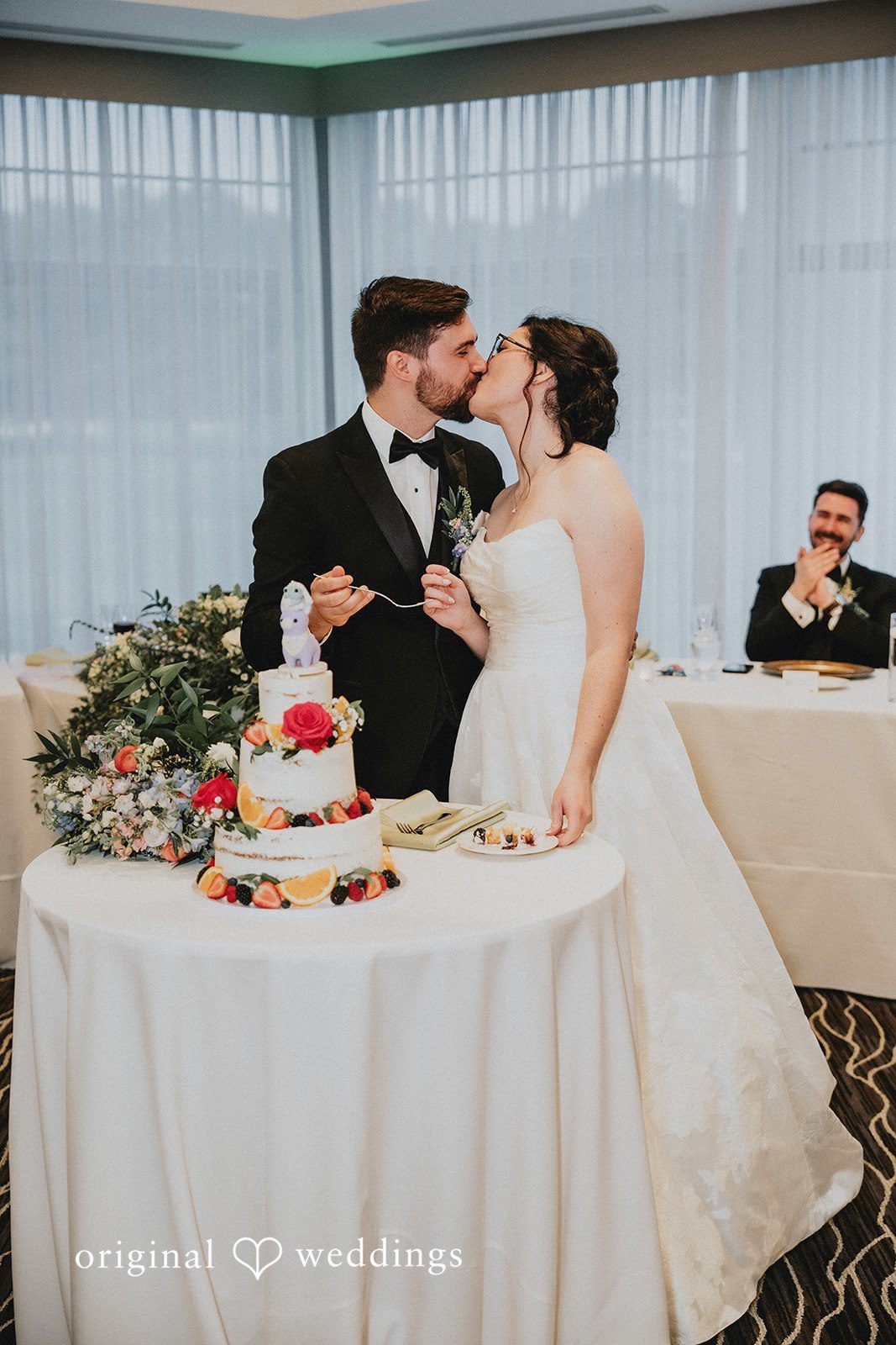 Brandon + Natalie A bride and groom standing behind a cake table at their reception.