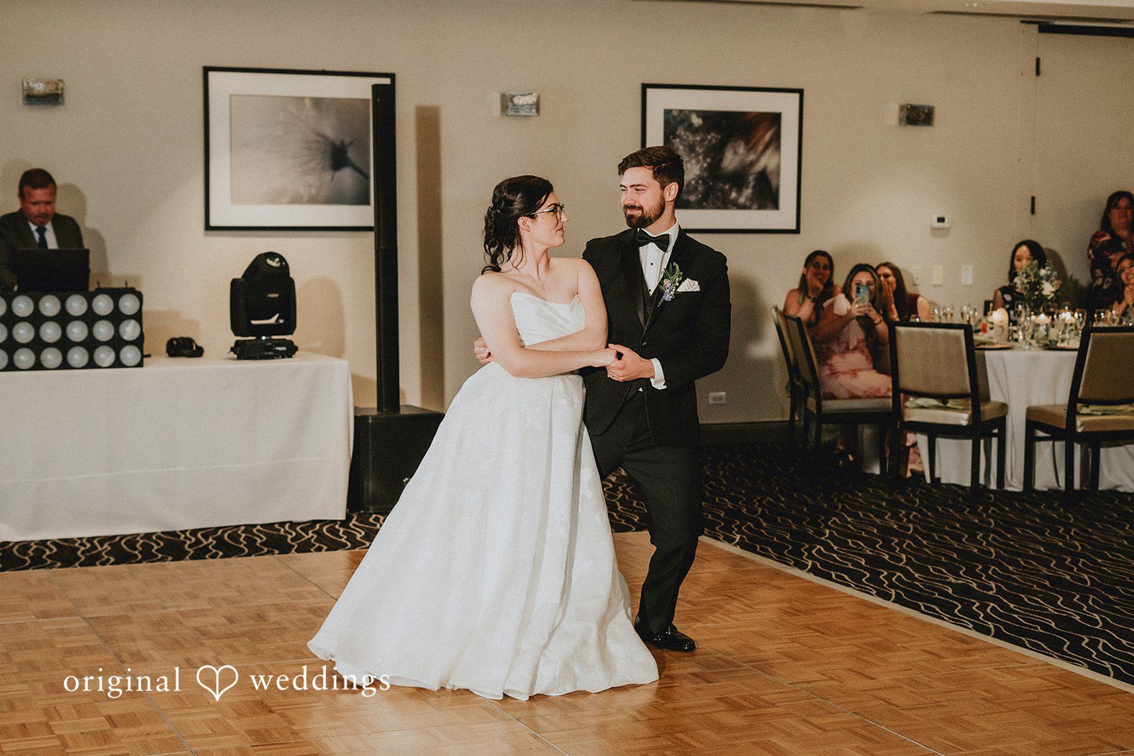 Brandon + Natalie A bride and groom dancing together in the center of a reception room.