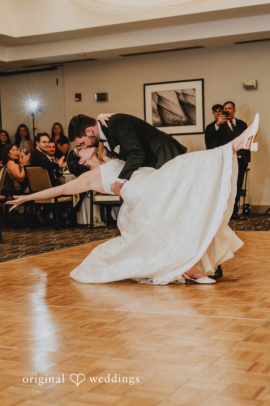 Brandon + Natalie A groom dipping a bride dynamically during a dance routine on the floor.